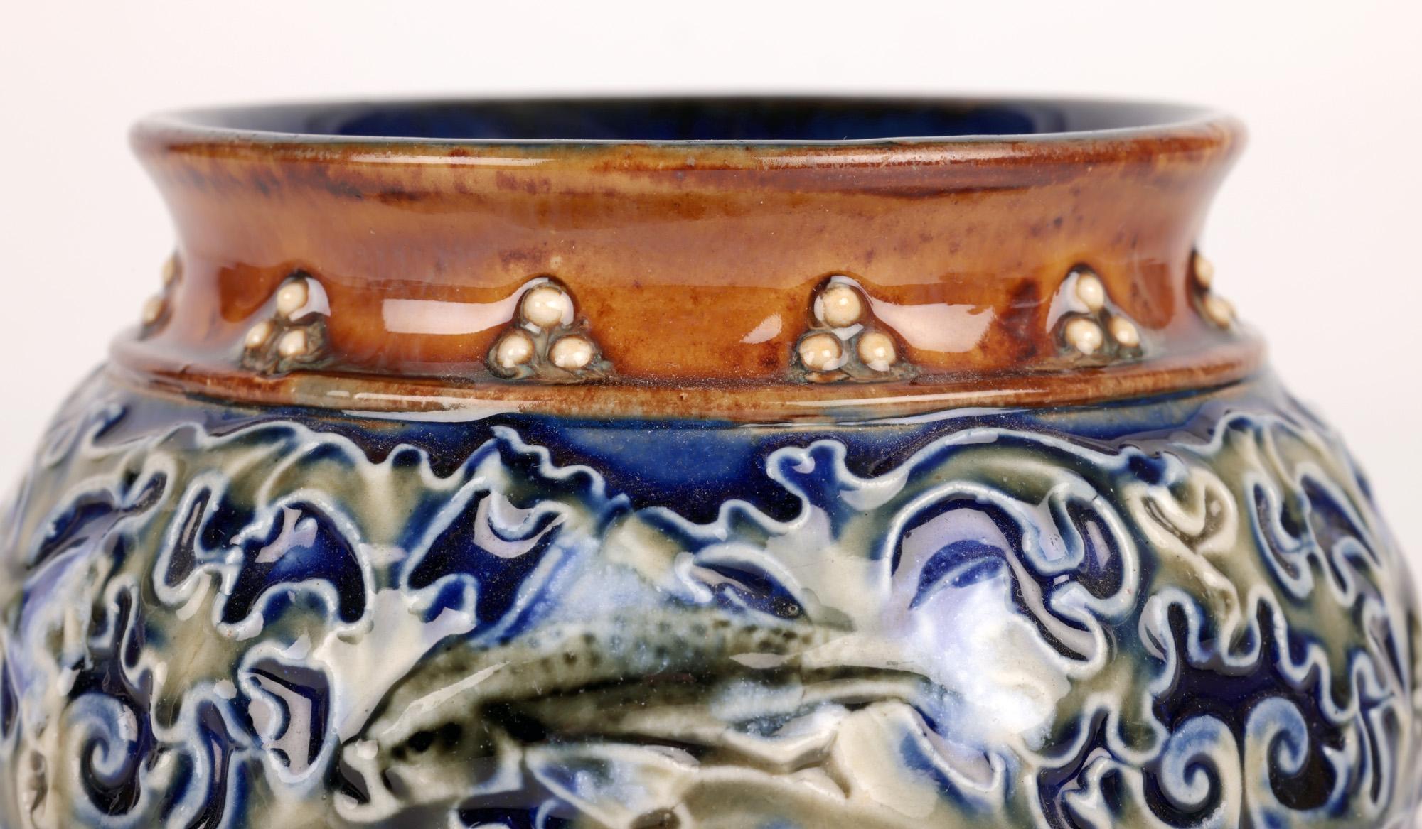 Un élégant vase Doulton Lambeth Art Pottery décoré de poissons par l'artiste de renom Maud Bowden et datant du début du 20e siècle. Le vase en grès est d'une forme ronde et bulbeuse peu profonde, reposant sur un pied étroit et rond, avec un bord