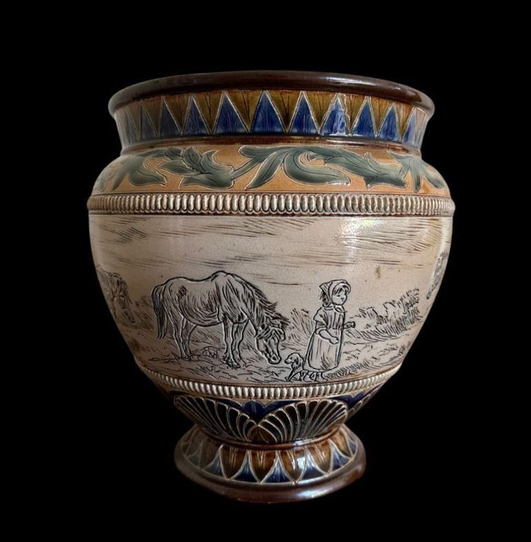 5409
Hannah Barlow for Doulton Lambeth, a Footed Jardiniere decorated with a Girl, a Puppy and Ponies. The Pair to item 5410
23 cm high, 21.5cm wide
Dated 1883