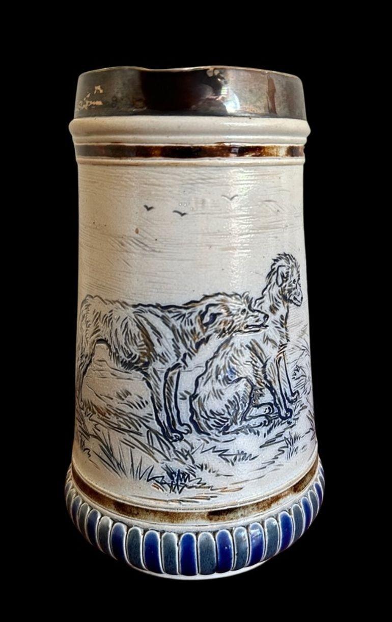5406
Hannah Barlow for Doulton Lambeth, a Jug with a Silver Rim decorated in sgraffito with Wolf Hounds
Firing Crack to handle
Signed to the base and the body
18.5cm high, 11cm wide
Dated 1876.