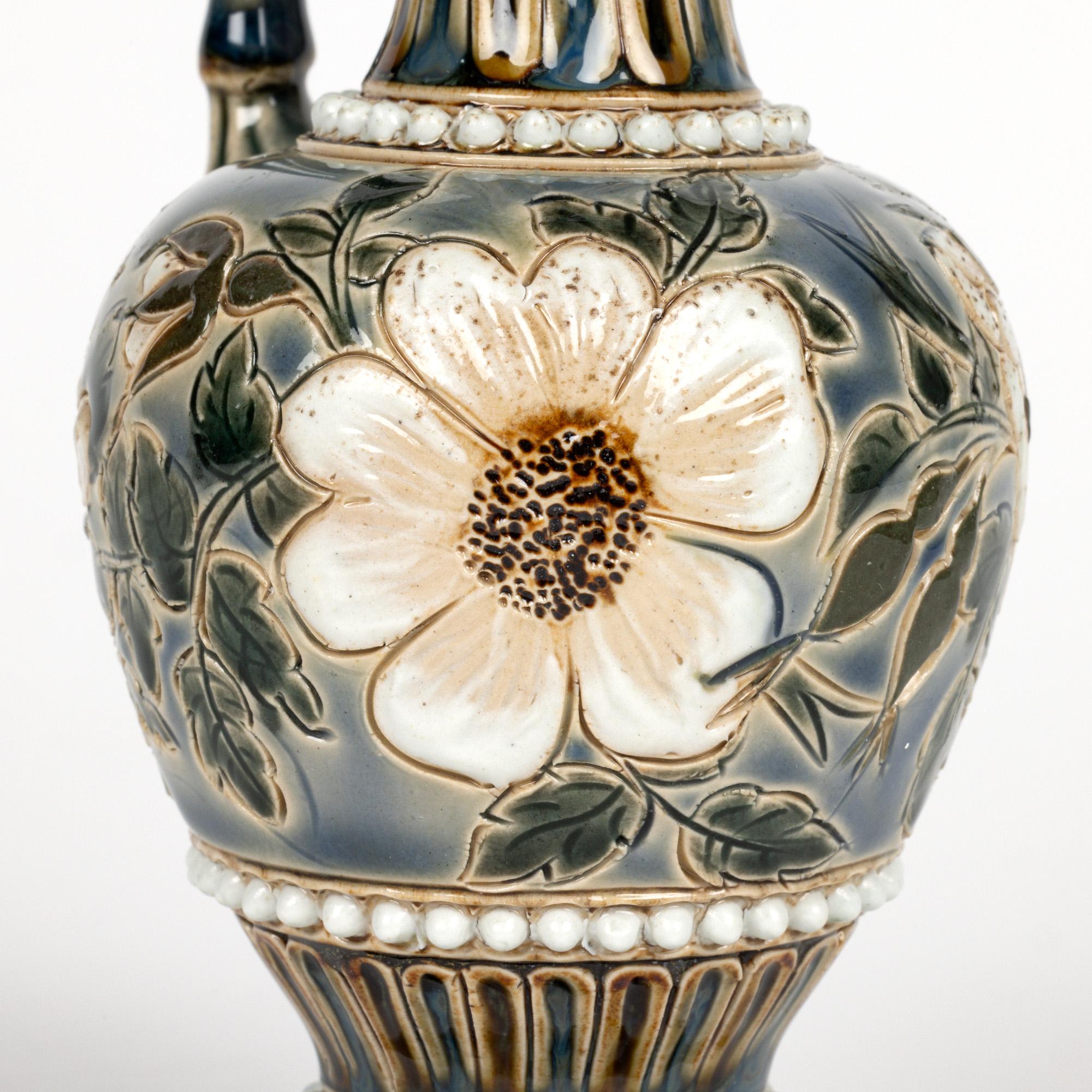 Ein feines Paar Aesthetic Movement Doulton Lambeth Kunst Keramik behandelt Ewers mit floralen und Perlen-Designs von renommierten Künstlern Laura Green und Alice Budden verziert und datiert 1884.  Die elegant geformten Ewers aus Steinzeug stehen auf