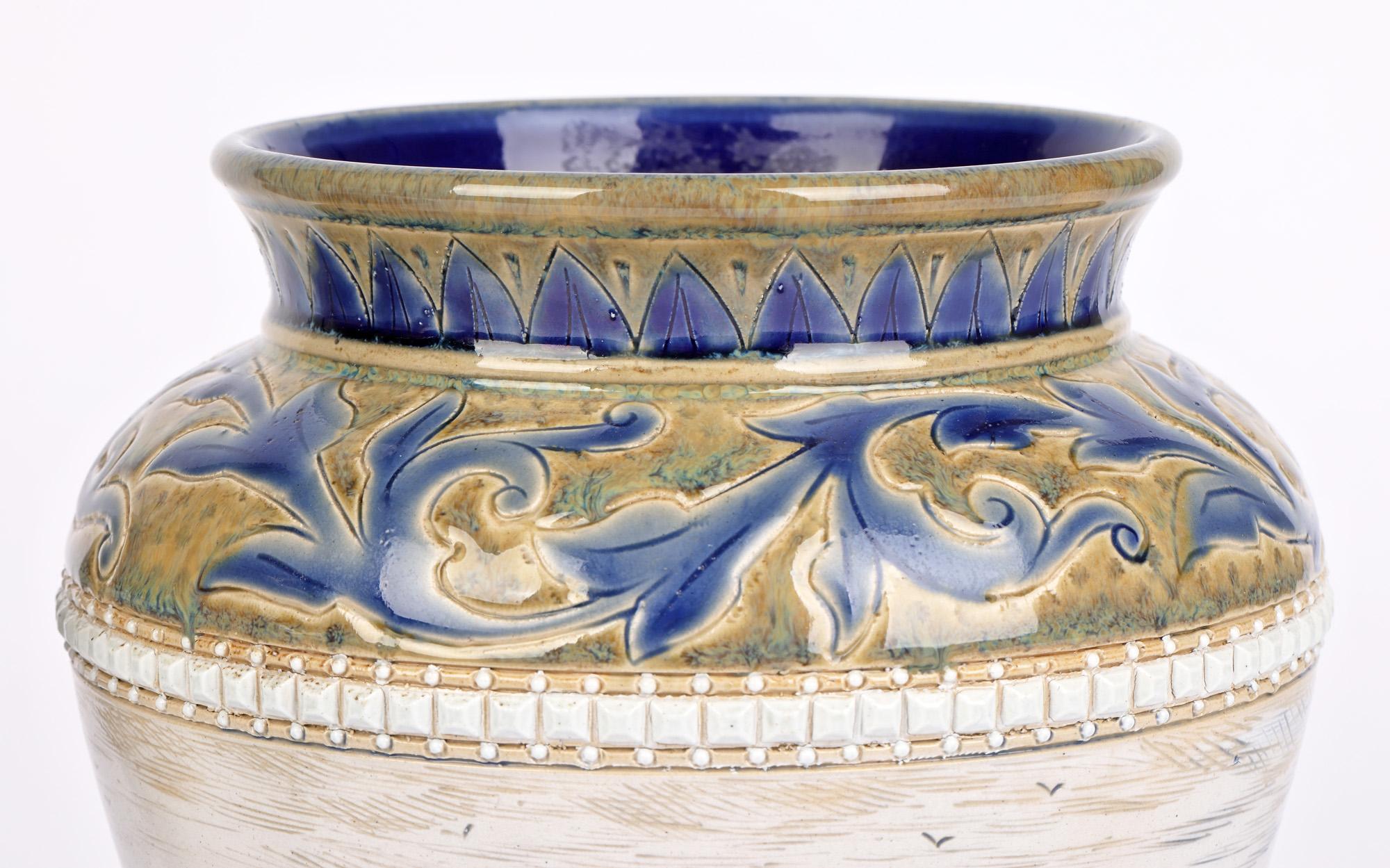 A rare and exceptional pair Doulton Lambeth art pottery vases decorated with continuous landscapes with deer by renowned artists Hannah and Florence Barlow and dated 1878. The vases stand on a narrow round pedestal foot with wide round bodies with