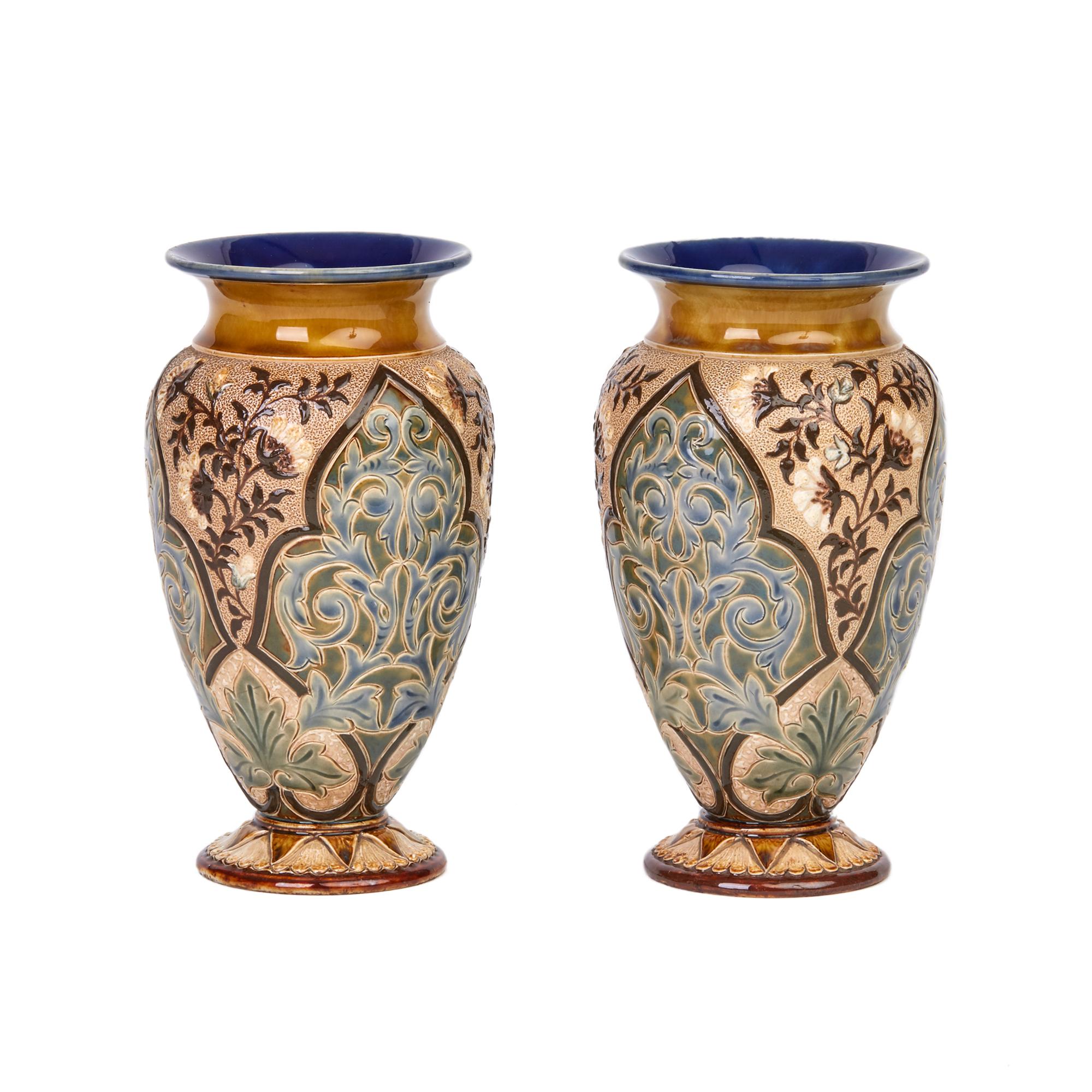 An exceptional and rare pair antique Doulton Lambeth art pottery stoneware vases exquisitely decorated with abstract scrolling leaf panels set between flowering stems made by Alice M E Barker and assisted by Alice Smith both dates 1883. The bulbous