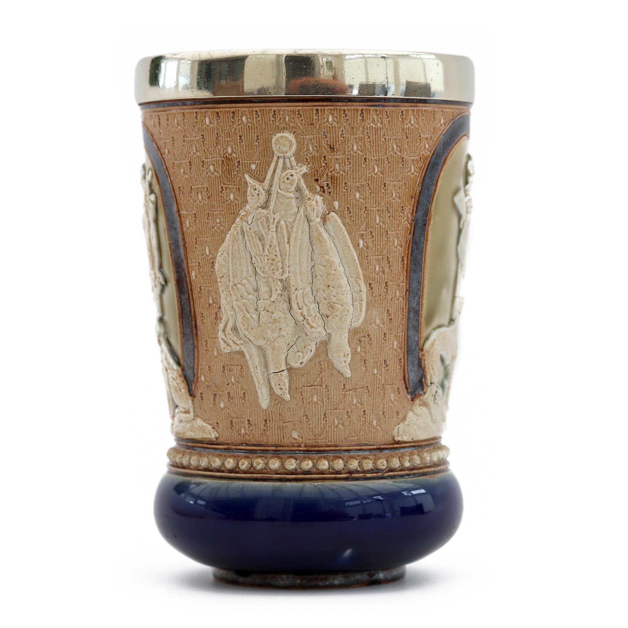 A very rare Doulton Lambeth art pottery Huntsman beaker decorated with figures of huntsmen by renowned artist Minnie Thompson and assisted by Matilda Martyn and Mary Lilly. The stoneware beaker dated 1882 is decorated with three panels each moulded