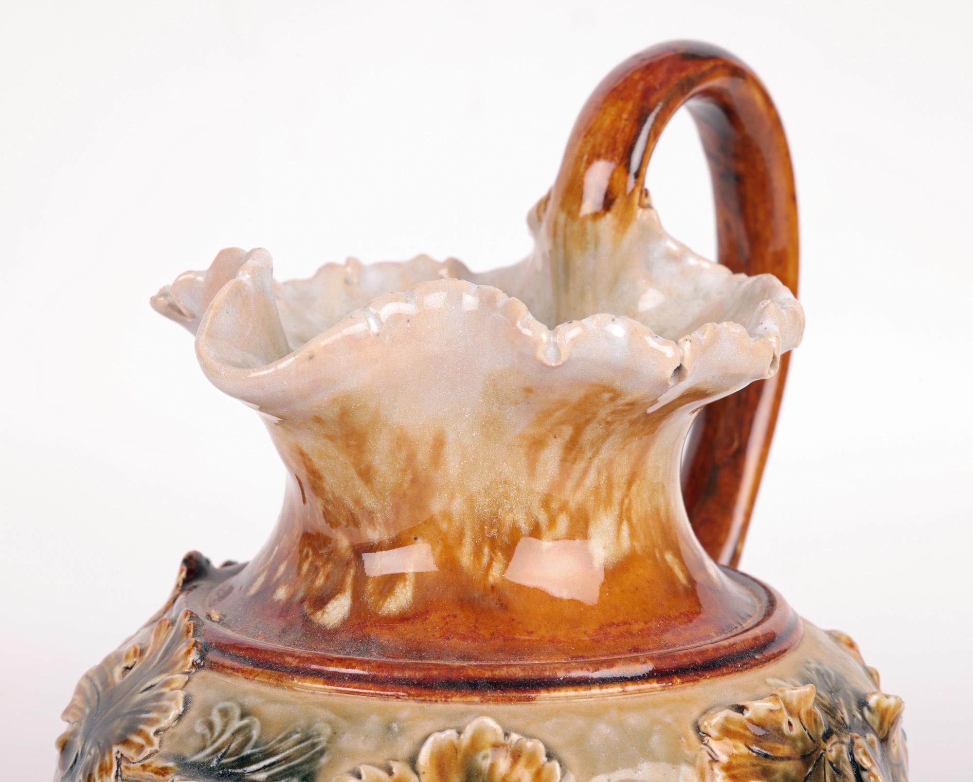 A rare and unusual Doulton Lambeth Art Pottery jug carved and decorated in relief with trailing fruiting vines by renowned and gifted modeler, designer and decorator Mark V Marshall and believed to date from around 1880. This unique jug stands on a