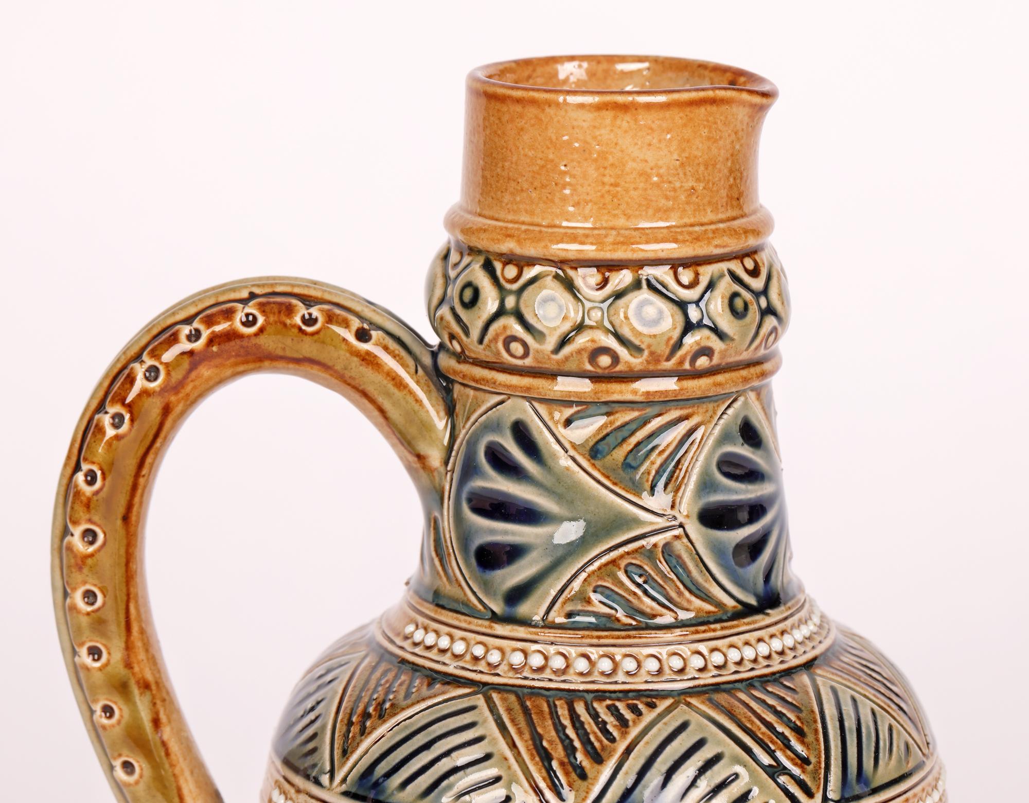 An exceptional and finely made Aesthetic Movement Doulton Lambeth stoneware ewer with geometric and stylized leaf patterning by renowned artist Edith D Lupton and dated 1875. An early example the ewer stands on a wide round foot with a wide round