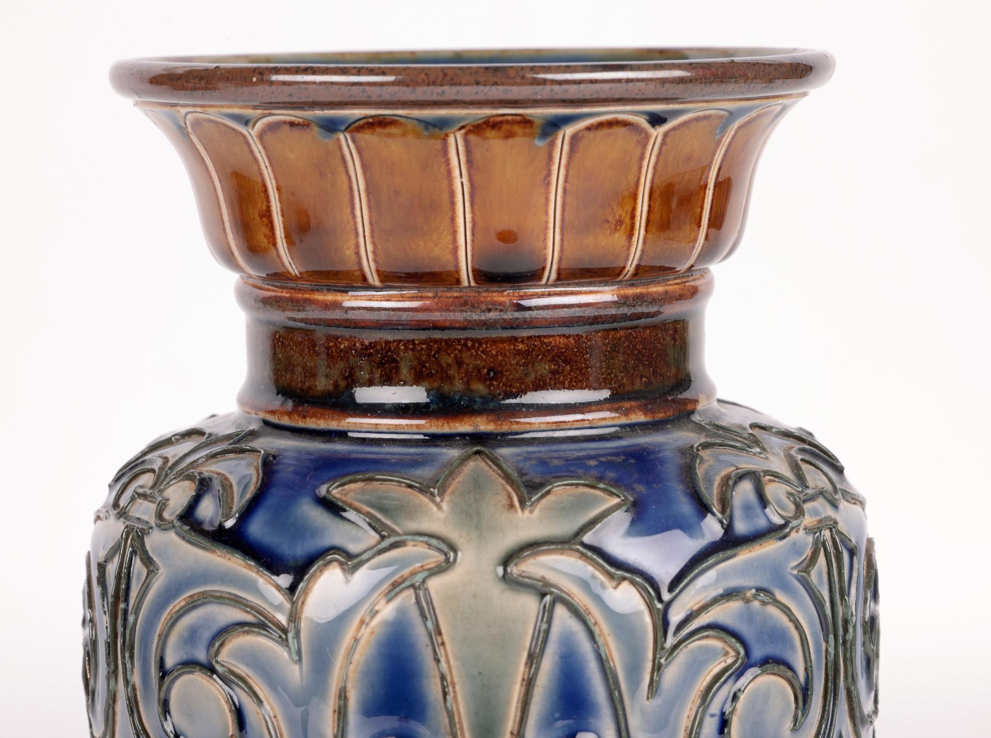 A very stylish Aesthetic Movement Doulton Lambeth tube lined stylized floral vase by renowned designer and decorator Eliza Simmance dated 1884. The tall stoneware vase stands raised on a raised shaped round pedestal base decorated with incised petal