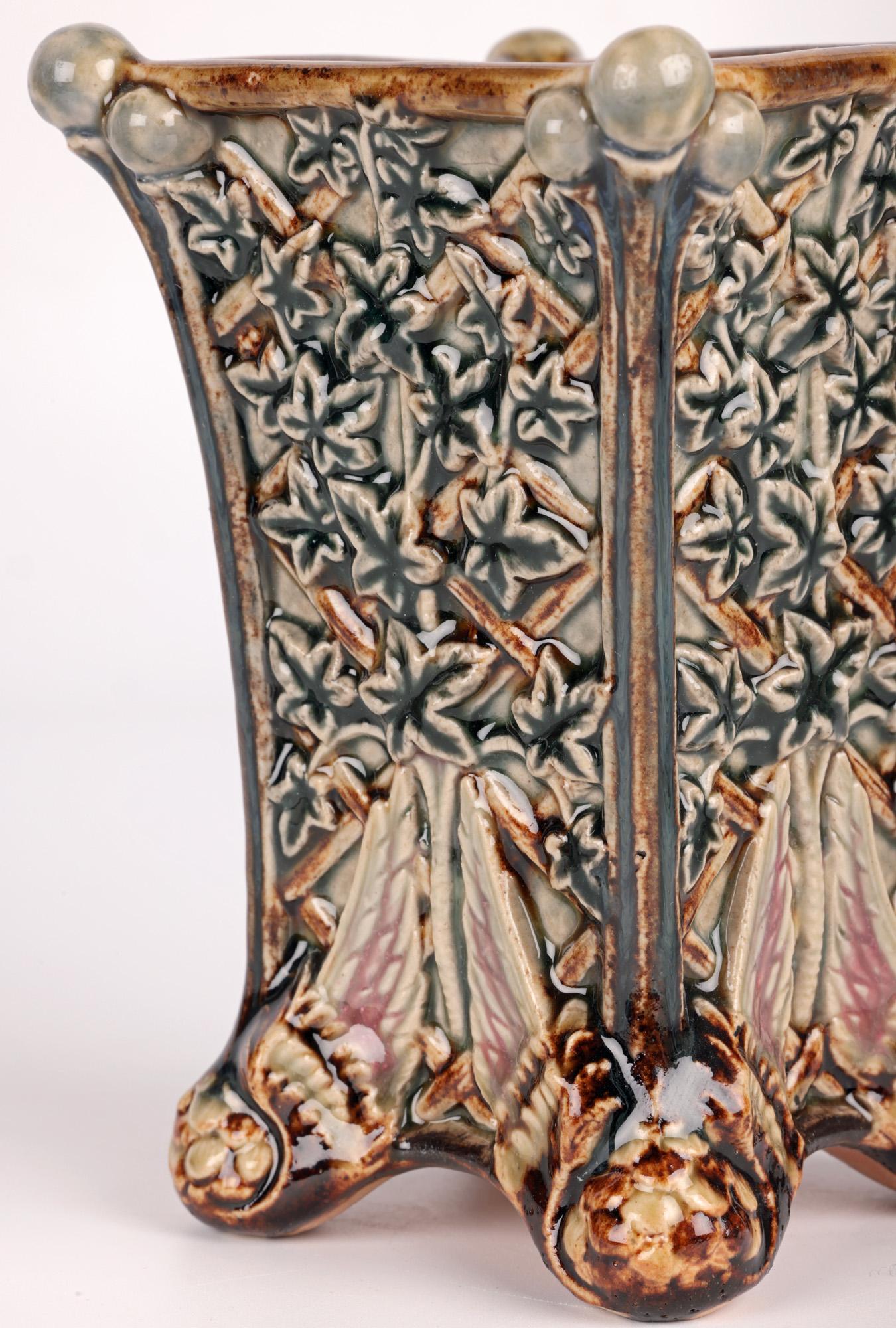 Un vase inhabituel et élégant de Doulton Lambeth Art Pottery décoré de lierre et de pieds ailés par l'artiste de renom Jane S Hurst, daté de 1880. Le vase en grès est de forme carrée effilée, reposant sur quatre pieds boules ornés d'ailes d'oiseaux.