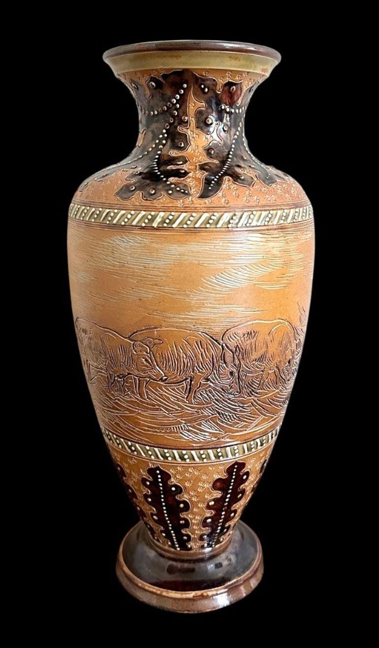 5405
Hannah Barlow for Doulton Lambeth, a Stoneware Vase decorated with Pigs between formal borders of Beaded Acanthus Leaves.
Nibbles to Base rim
31.5cm high, 14cm wide
1891 - 1902.