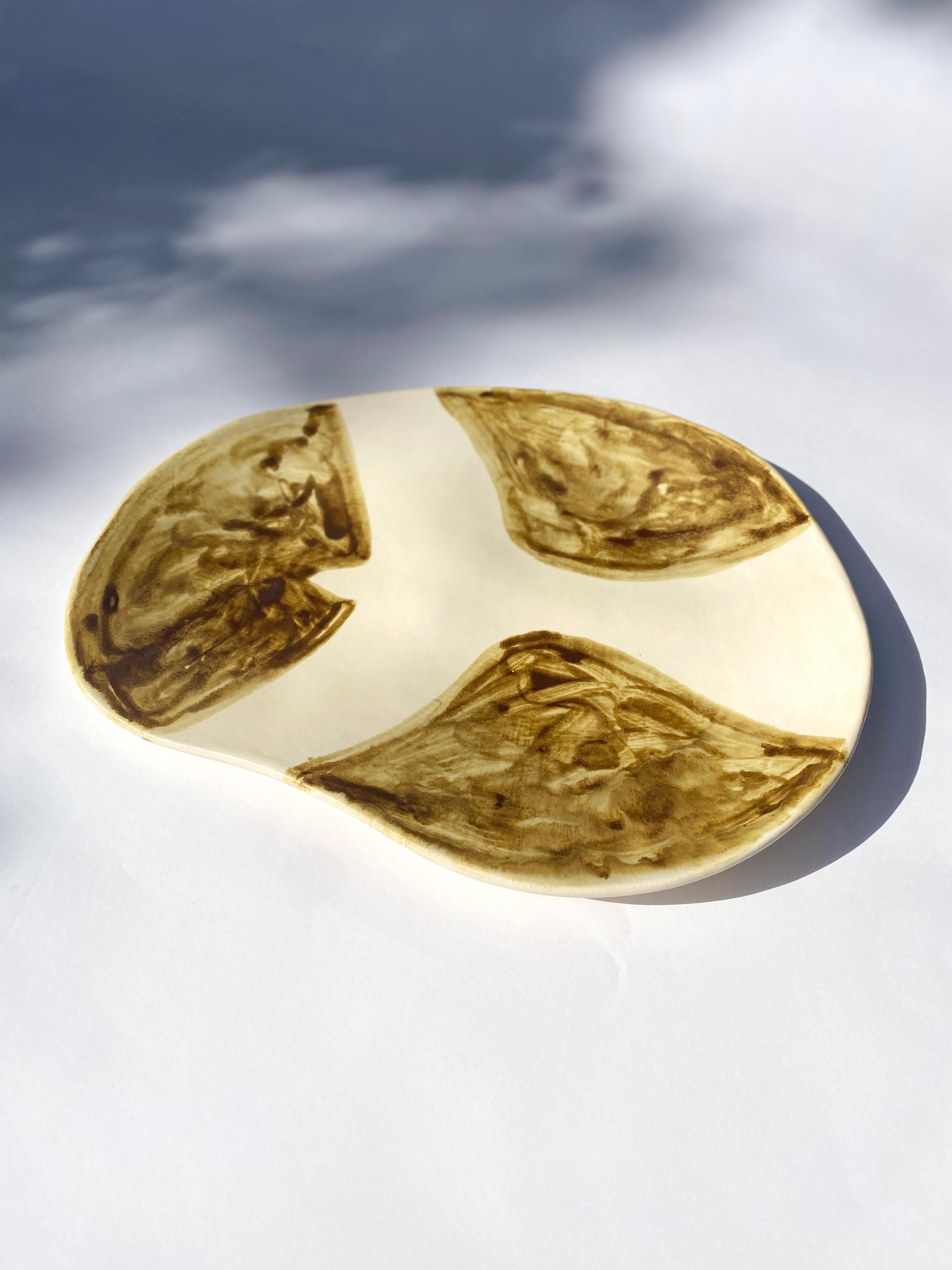 This one-of-a-kind ceramic platter was handmade in Hudson, NY by artist Sarah Mijares Fick.

Finished with a satin white glaze and a hand-painted ochre dove design, this platter is an elegant and unique statement piece. Subtle indentations act as