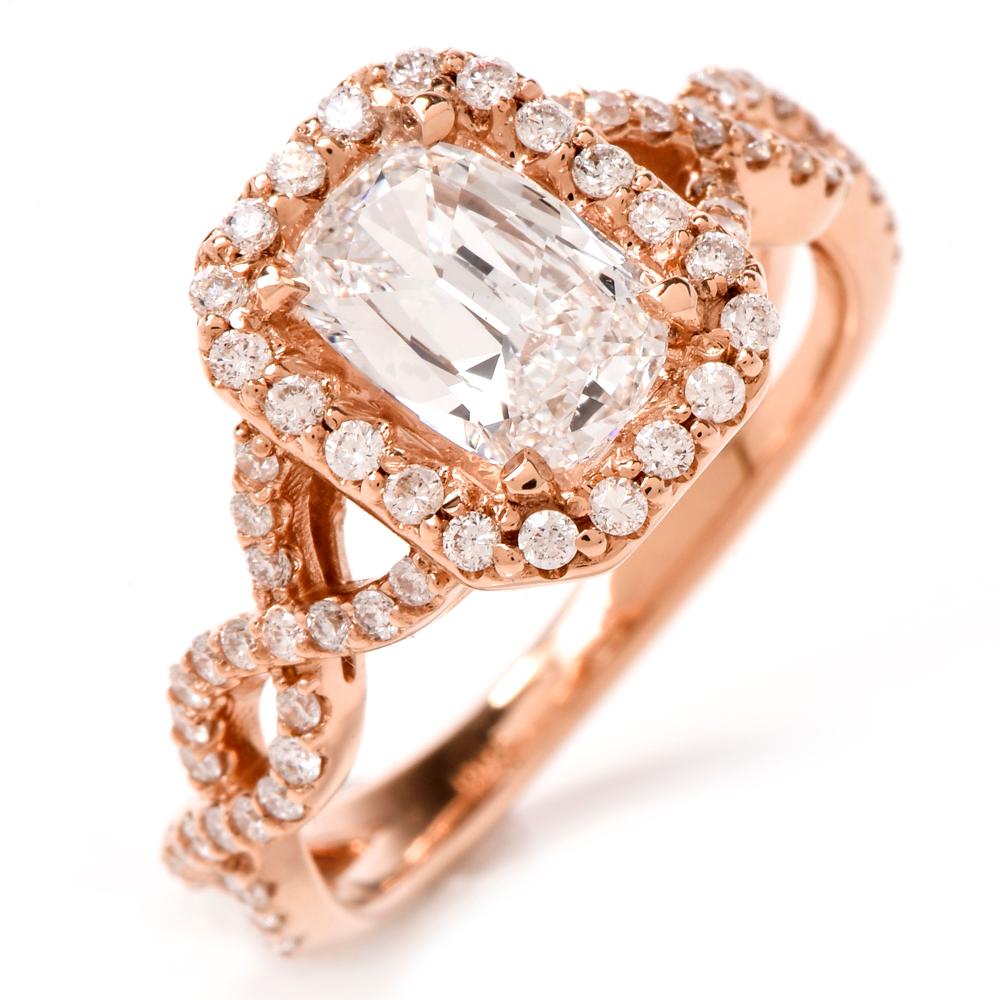 This stunning  Diamond ring is crafted in 18K rose gold. Displaying a prominent four prong set emerald cut diamond approx. 1.01 CT, D color, VS1 clarity. Surrounded by a halo of pave set round-cut diamonds, further embellished along a twisted shank