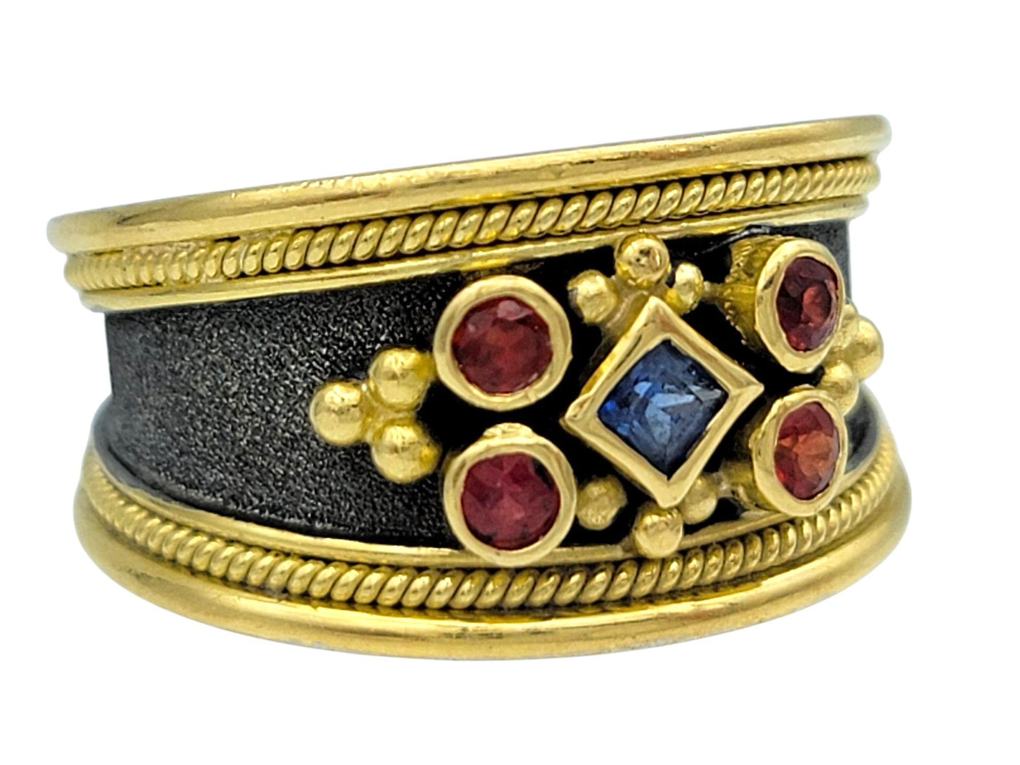 Contemporaneo Dovris Anello a fascia con dettaglio di zaffiri rossi e blu in oro giallo 18 carati in vendita