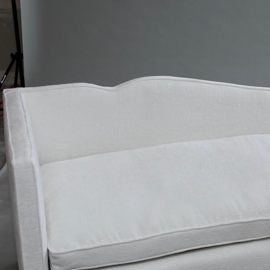 Vintage left arm facing chaise lounge or daybed that has just been reupholstered in a soft white chenille. This is a heavy, well-made chaise that is heirloom quality and built to provide a relaxing experience for another generation.