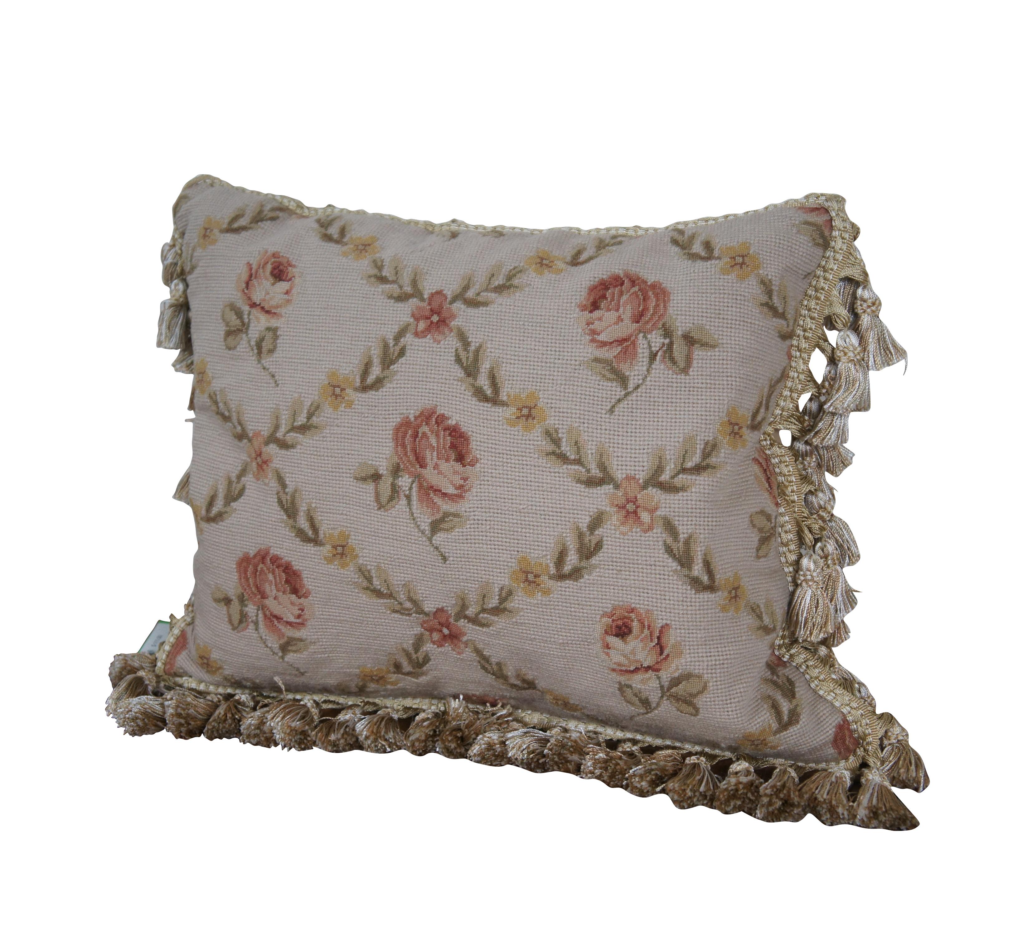 2 Available - 20th century square needlepoint throw pillow, hand embroidered with a pattern of pink roses, divided by criss crossing lines of pink and yellow flowers and leaves, on a beige background. Cream and gold tassel trim. Beige velour back