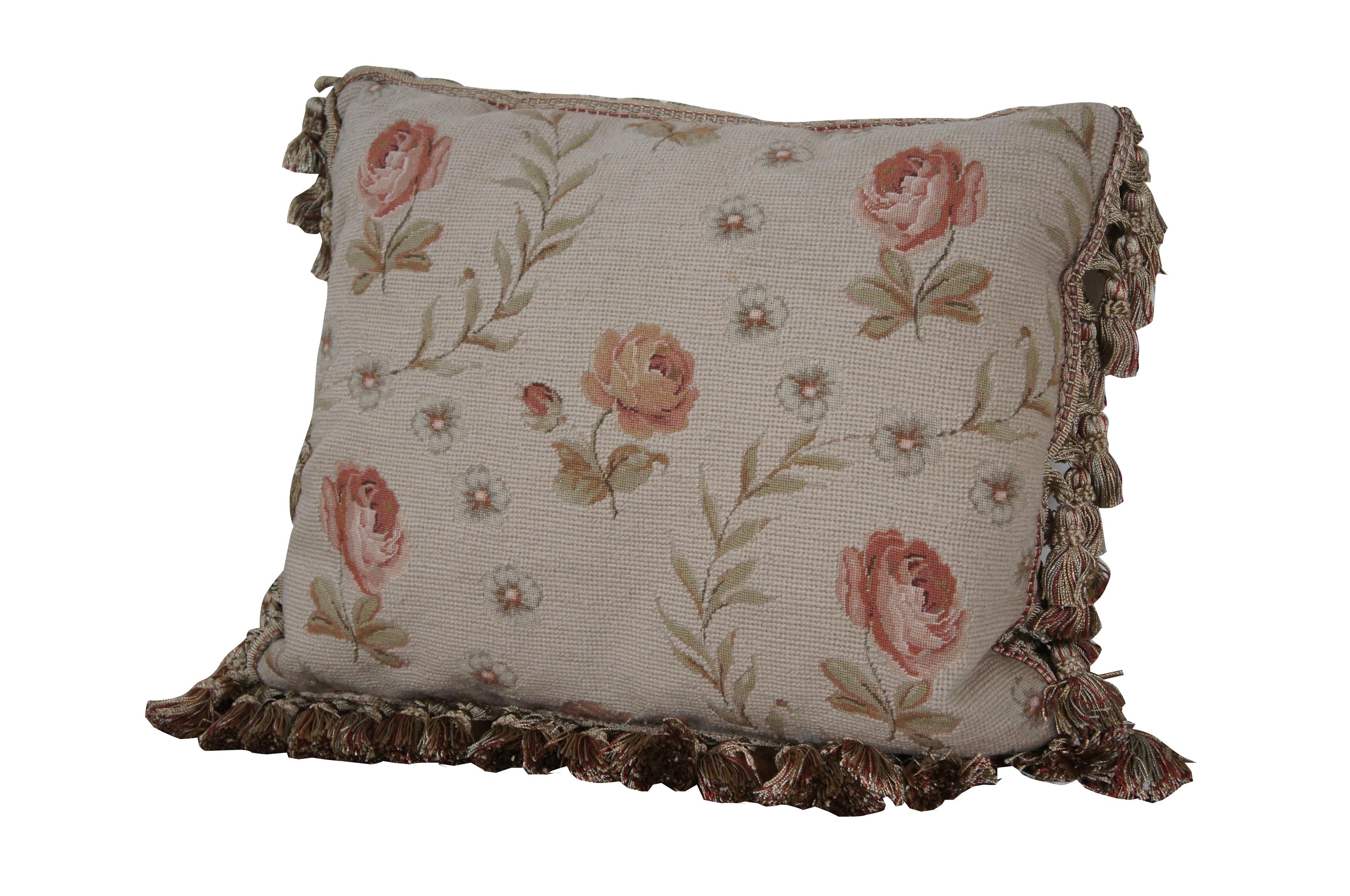 20th century rectangular needlepoint lumbar / throw pillow, hand embroidered with pink roses, separated by arching stems of leaves and light green flowers. Red and beige tassel trim. Beige velour back with zipper closure. Down