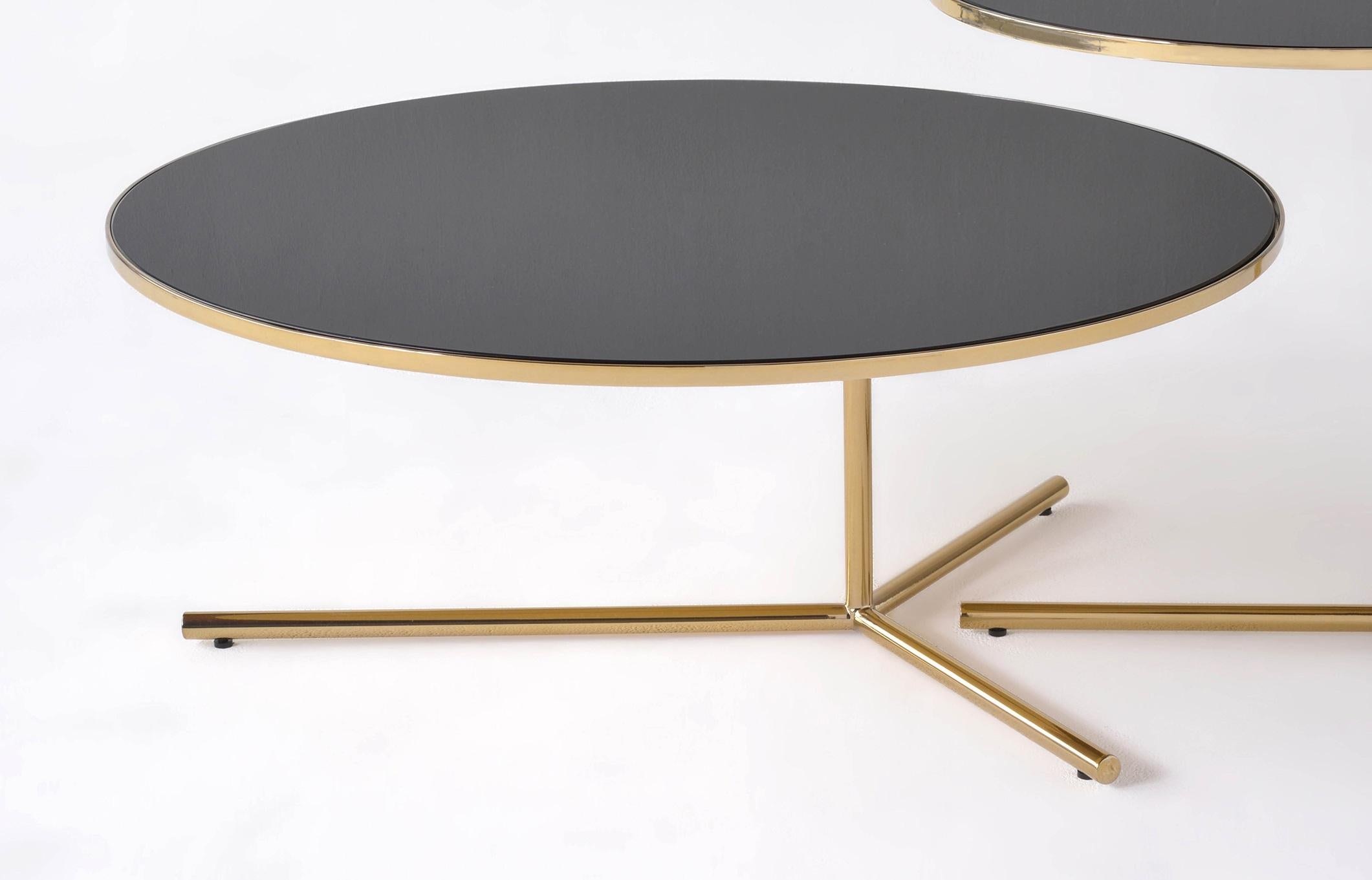 Downtown Large Table by Phase Design
Dimensions: Ø 76,2 x H 30,5 cm. 
Materials: Spandrel glass, steel and polished brass.

Solid steel base available in flat or gloss black and white powder coat, polished chrome, burnt copper, or smoked brass