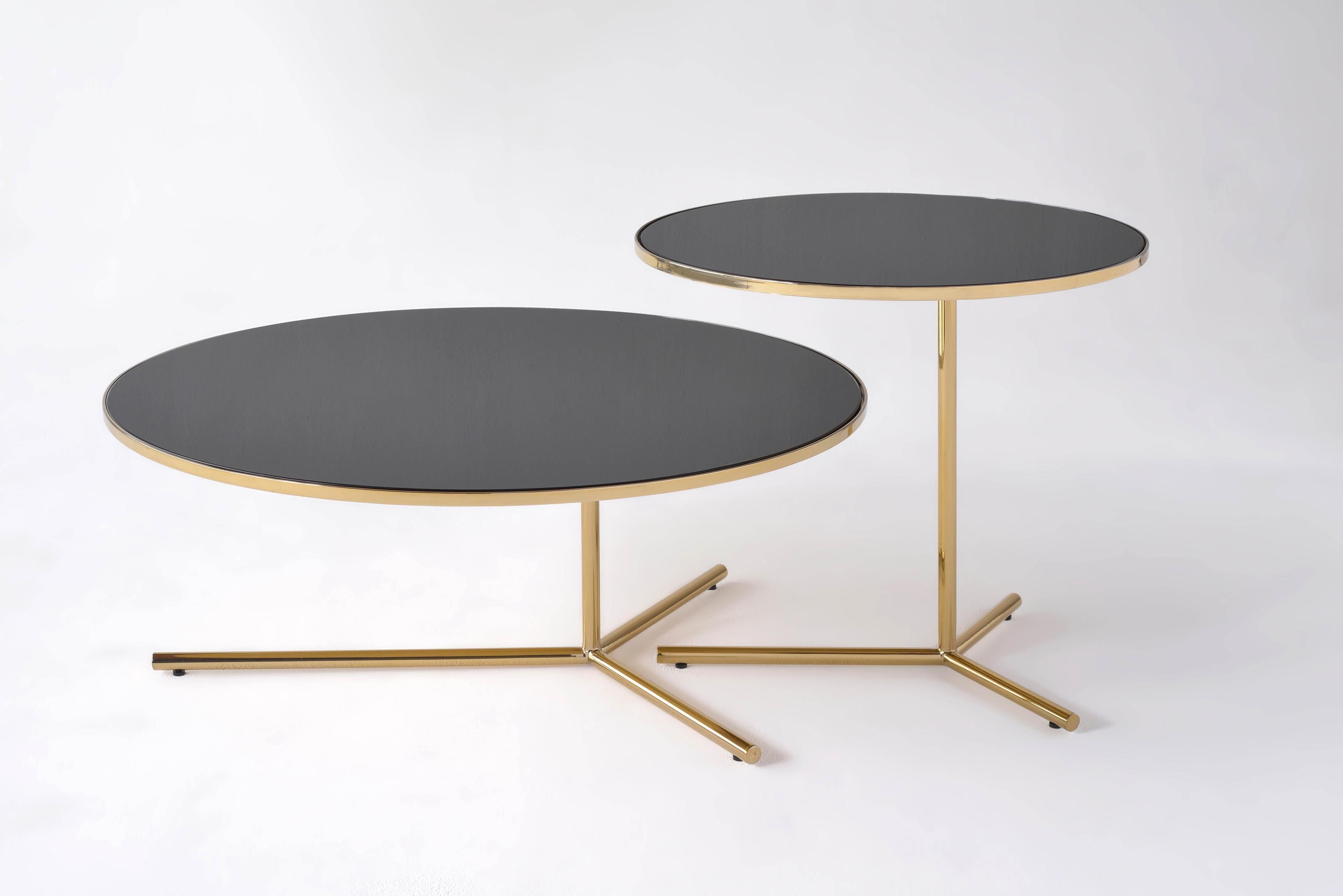 The Downtown Tables are composed of three separate tables, intended to be used individually or in conjunction
with one another. An offset leg allows for nesting these tables in various forms and compositions. The table’s spandrel glass top is housed