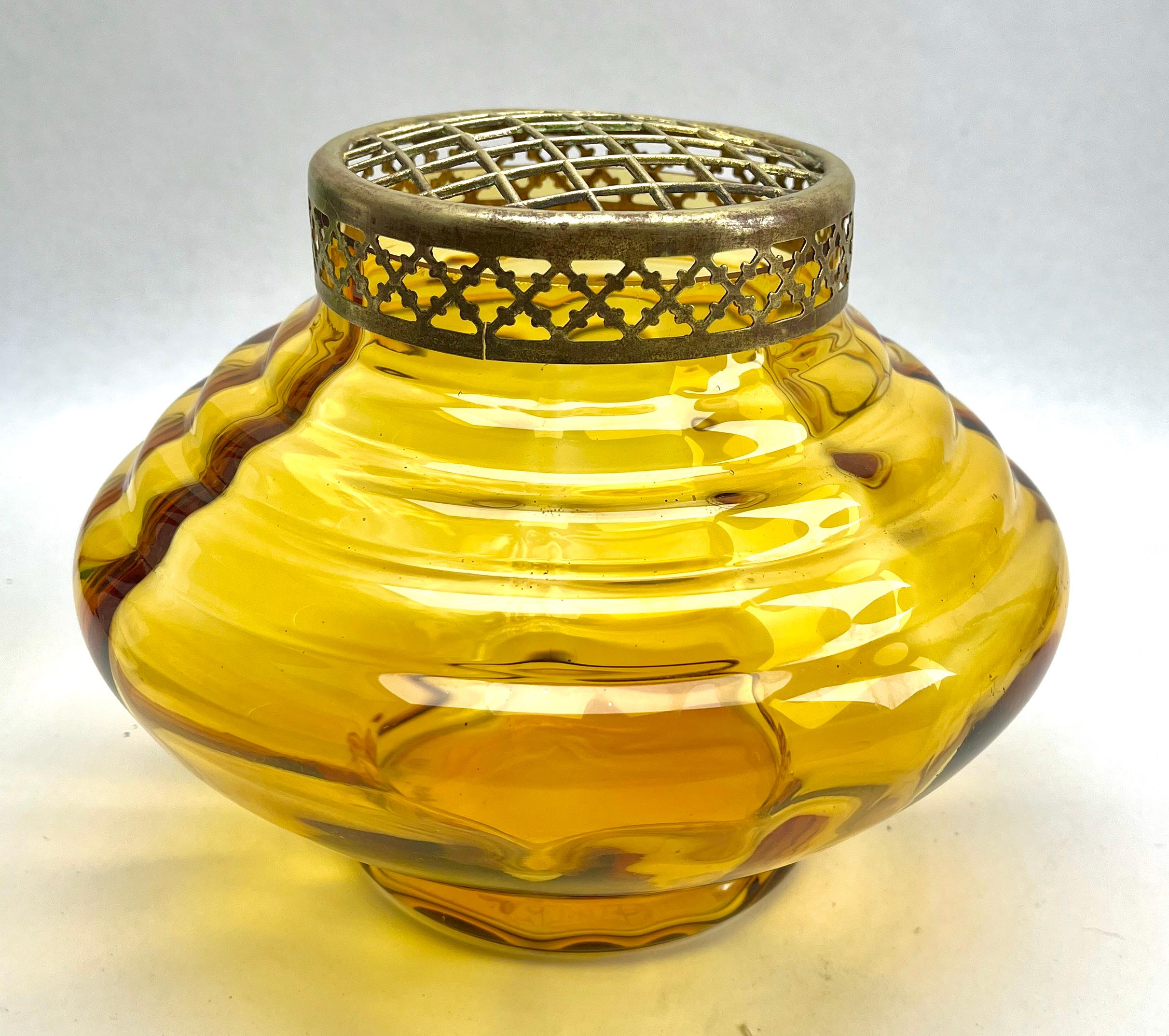 Doyen 'Pique Fleurs' Vase with Grille, Late 1930s

Subtle, hand blown glass vase in the Art Deco style. This design for vases is often called 'Pique fleurs' or 'rose-bowl' and is supplied with a fitted metal grille to support stems in an