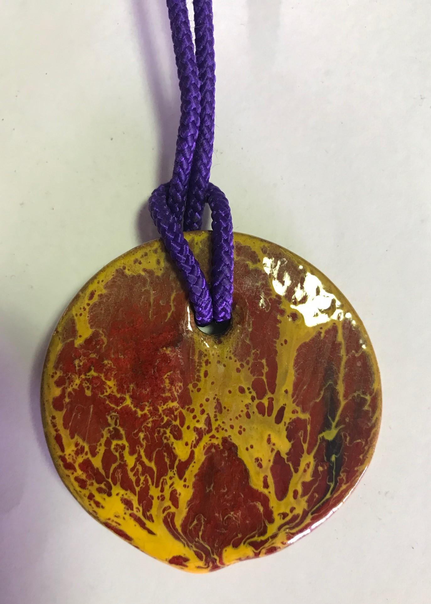 A beautifully glazed and colored ceramic pendant by famed midcentury American artist/potter Doyle Lane. Lane was a glaze specialist much like Glen Lukens and Otto Natzler. His colorful glazes would melt, bubble and crack over his pieces creating a