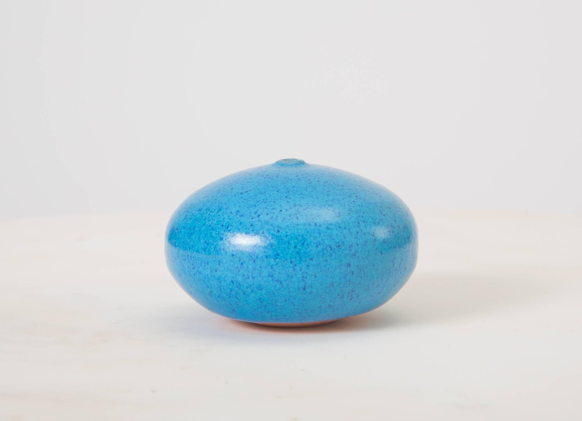 A one-of-kind weed pot by Los Angeles ceramics artist Doyle Lane. This diminutive example has a deceptively simple ovoid shape in a dimensional robin’s egg blue glaze with a matrix of suspended darker blue flecks. The glaze coats the upper ¾ of the