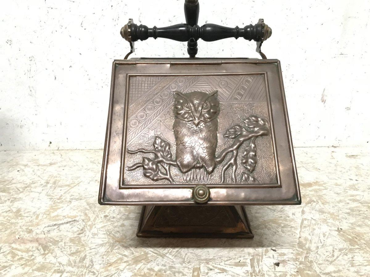 Dr Christopher Dresser for Benham and Froud.
A rare Aesthetic Movement copper and brass coal scuttle with turned Ebony handle, the whole stood on a flared base with all-over stylised sunflower and foliage decoration. 
An embossed owl perched on a