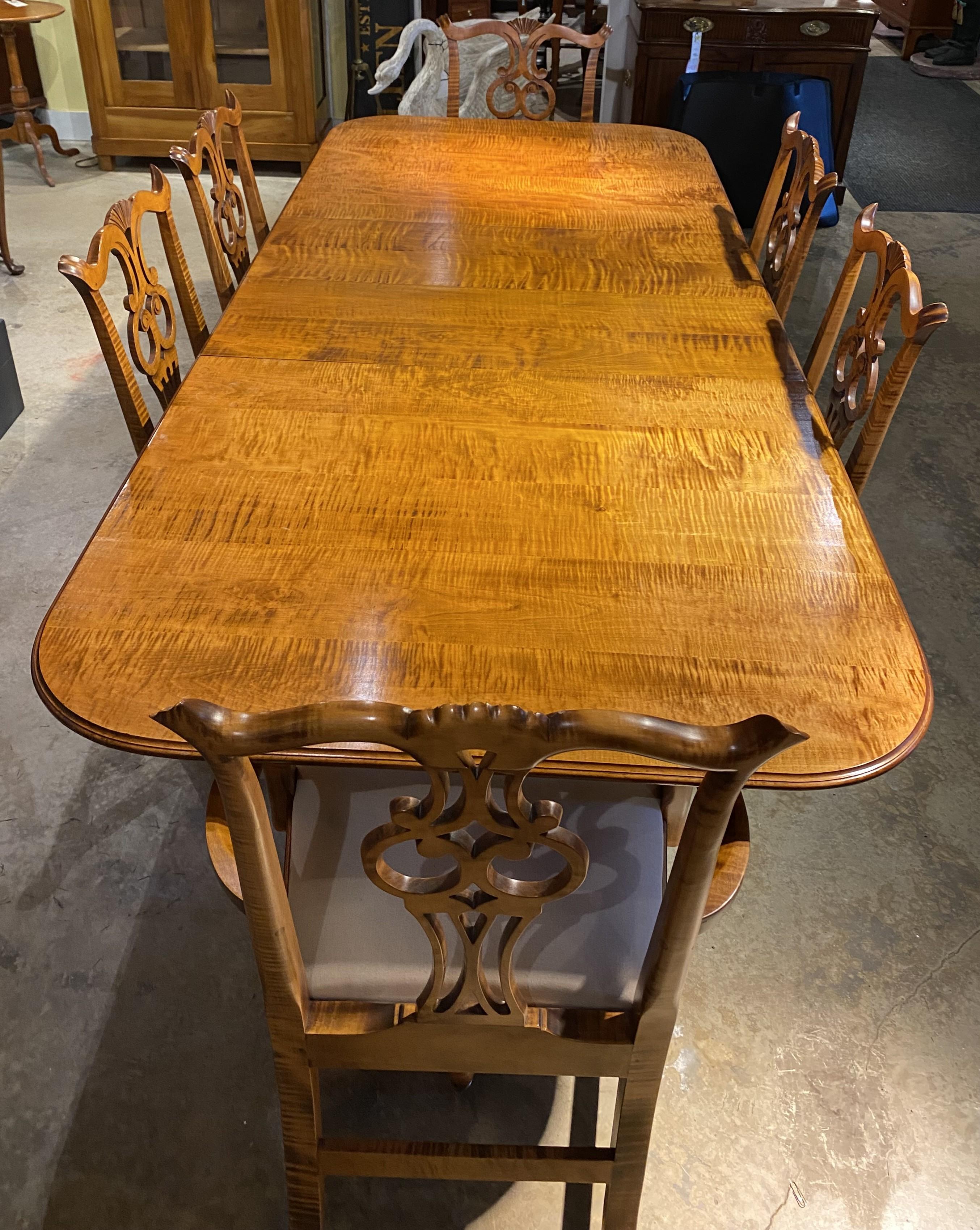 Un spectaculaire ensemble de salle à manger de style Chippendale en érable tigré comprenant une table à manger rectangulaire à double piédestal avec deux feuilles et six chaises, deux fauteuils et quatre chaises d'appoint fabriqués à la main par le