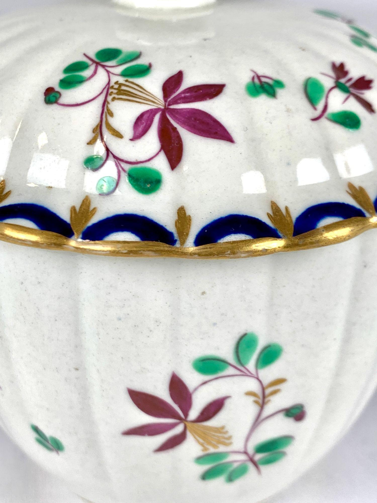 This is a hand-painted First-Period Worcester Porcelain sugar box from the 18th century.
The lively floral design is painted in green, blue, purple, and gilt.
We see purple stems and purple flowers with gilt stamens, along with green and gilt