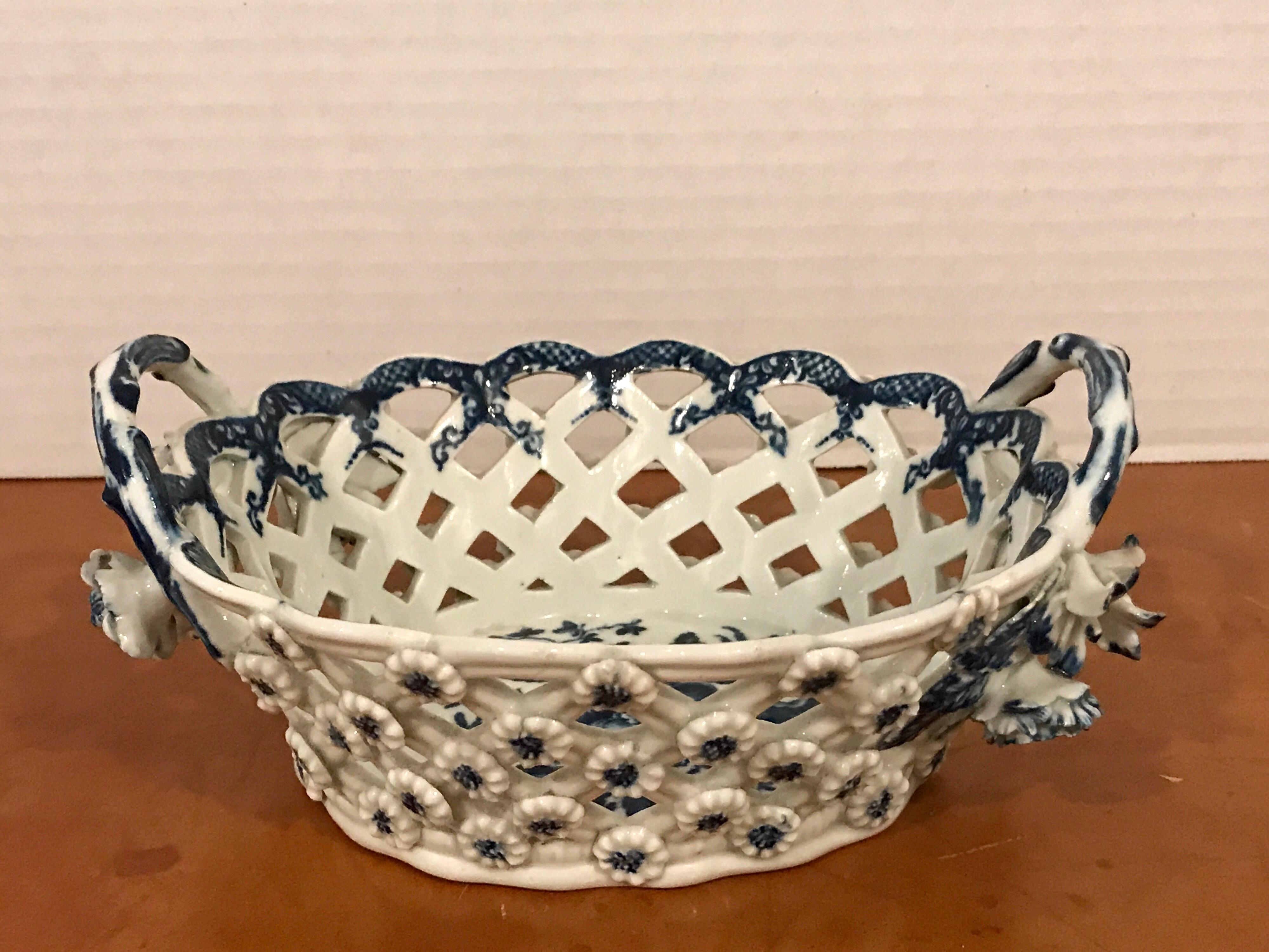 Dr. Wall period Worcester porcelain blue and white basket, England, 18th century, of oval form with scalloped rim and pierced basket weave sides and twisted twig handles, the exterior adorned with florets, underglaze blue interior with fruit and