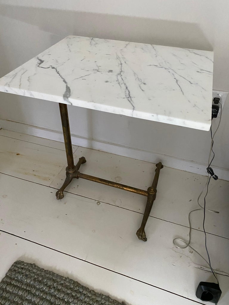 Antique adjustable tilt-top table with gold gilt cast iron clawfoot base. The original wood top has been replaced by a white marble one that now lends itself to be used as an end table, side table, bedside table or nightstand. Height (when top is
