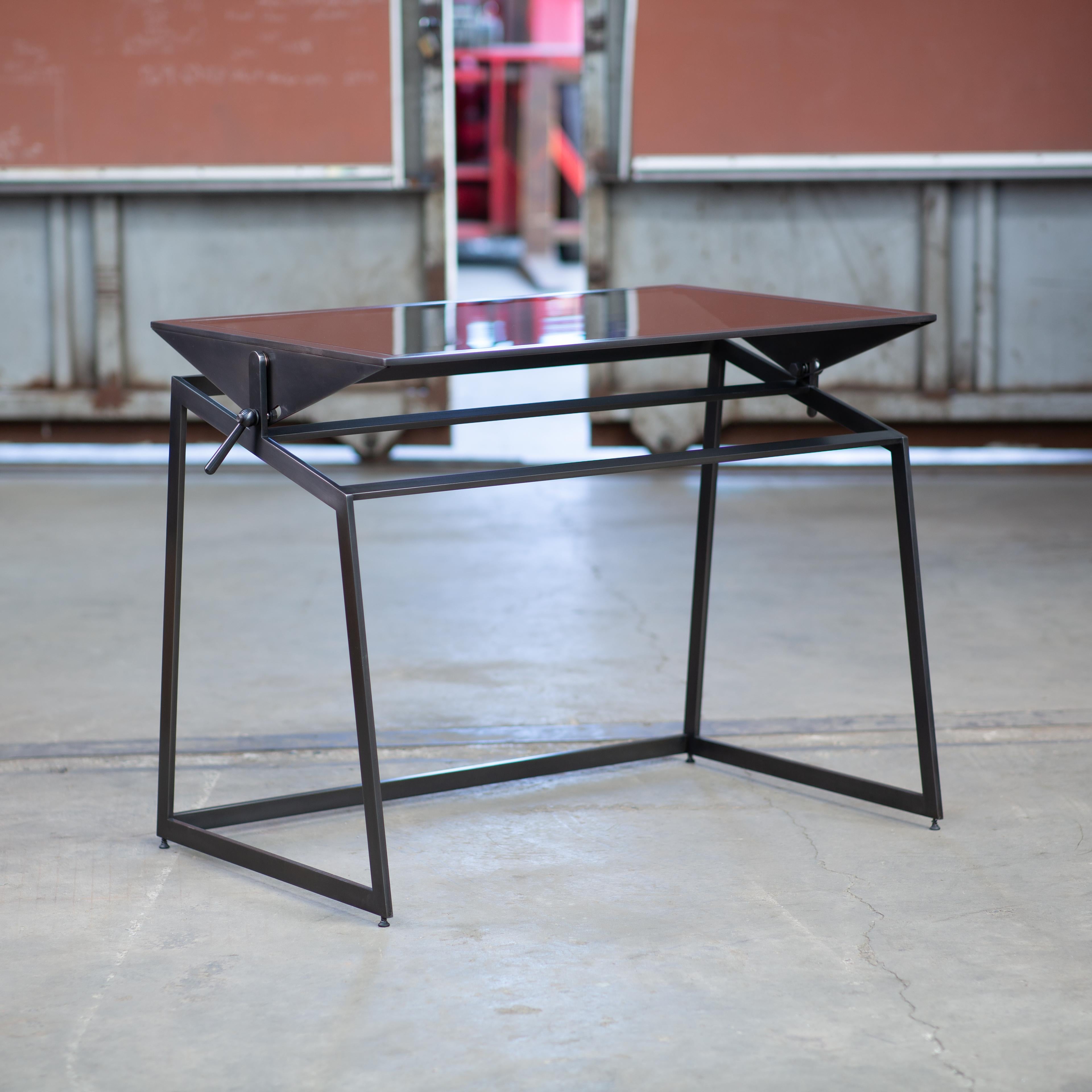 Designed and made-to-order in our Seattle studio with artists, architects, drafters, designers and creatives in mind, the Pivoting Drafting Table is modern, minimal and sleek. It features a satin black oxide steel framework with a tempered gray