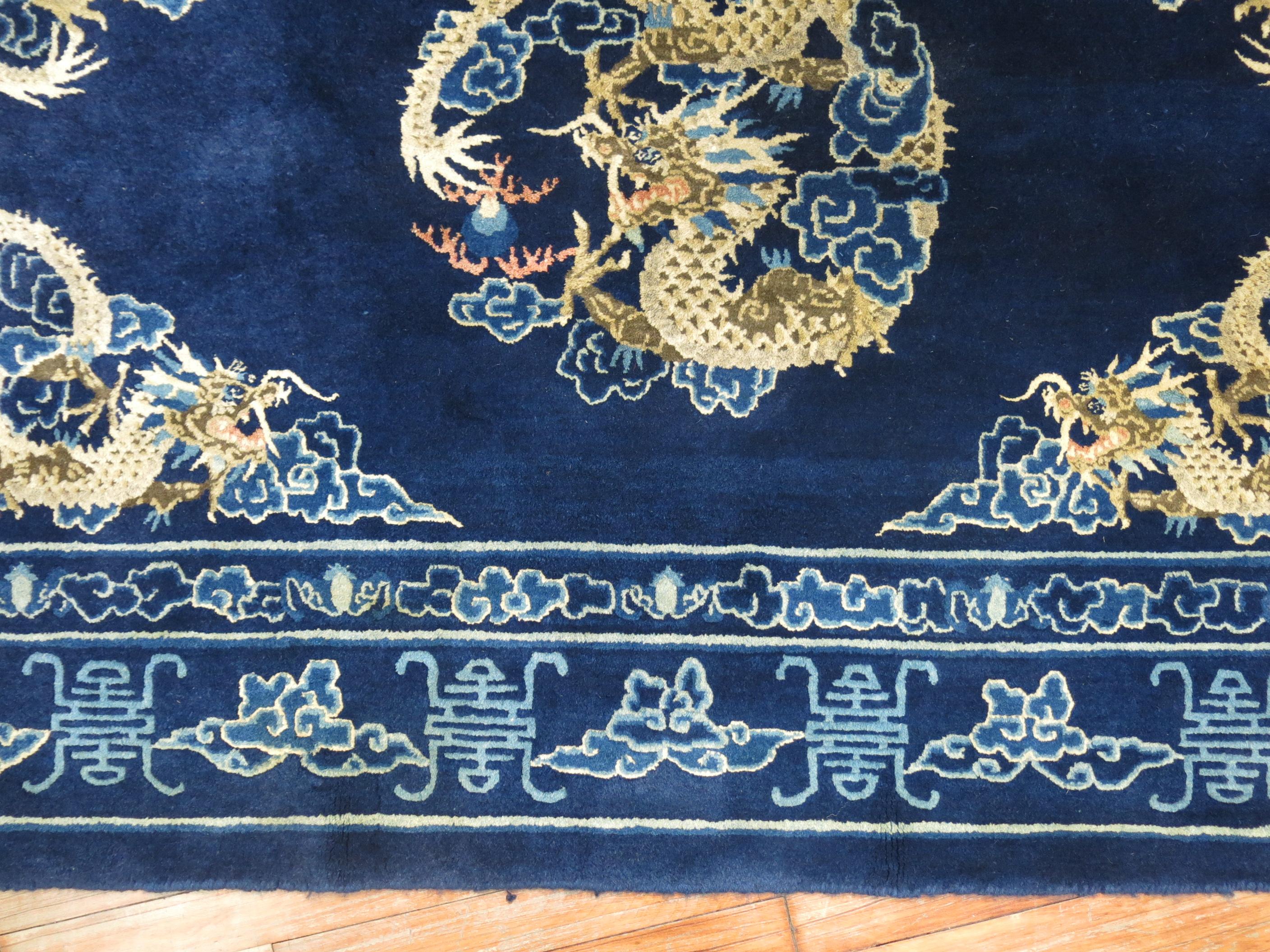 A full pile 20th century Chinese rug with 4 dragons floating on a navy blue ground.

Measures: 4'1