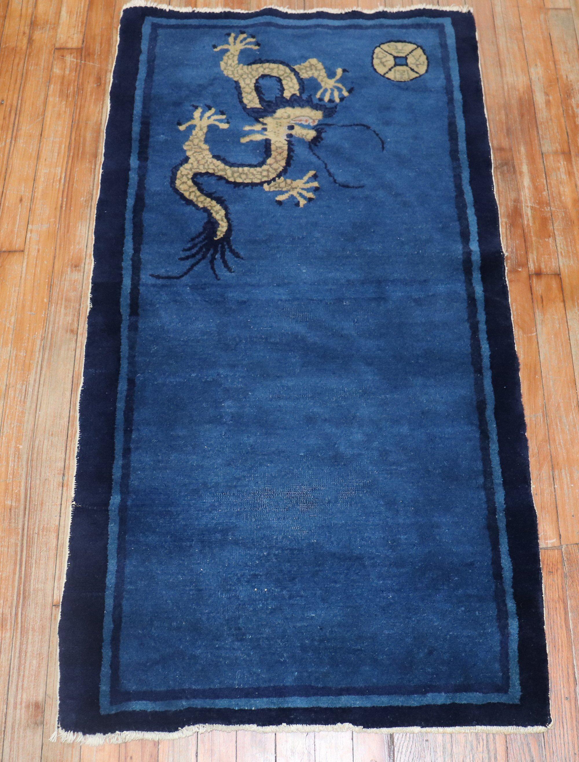 An early 20th century Chinese rug with 1 dragon floating on a plain blue ground

Measures: 2'6