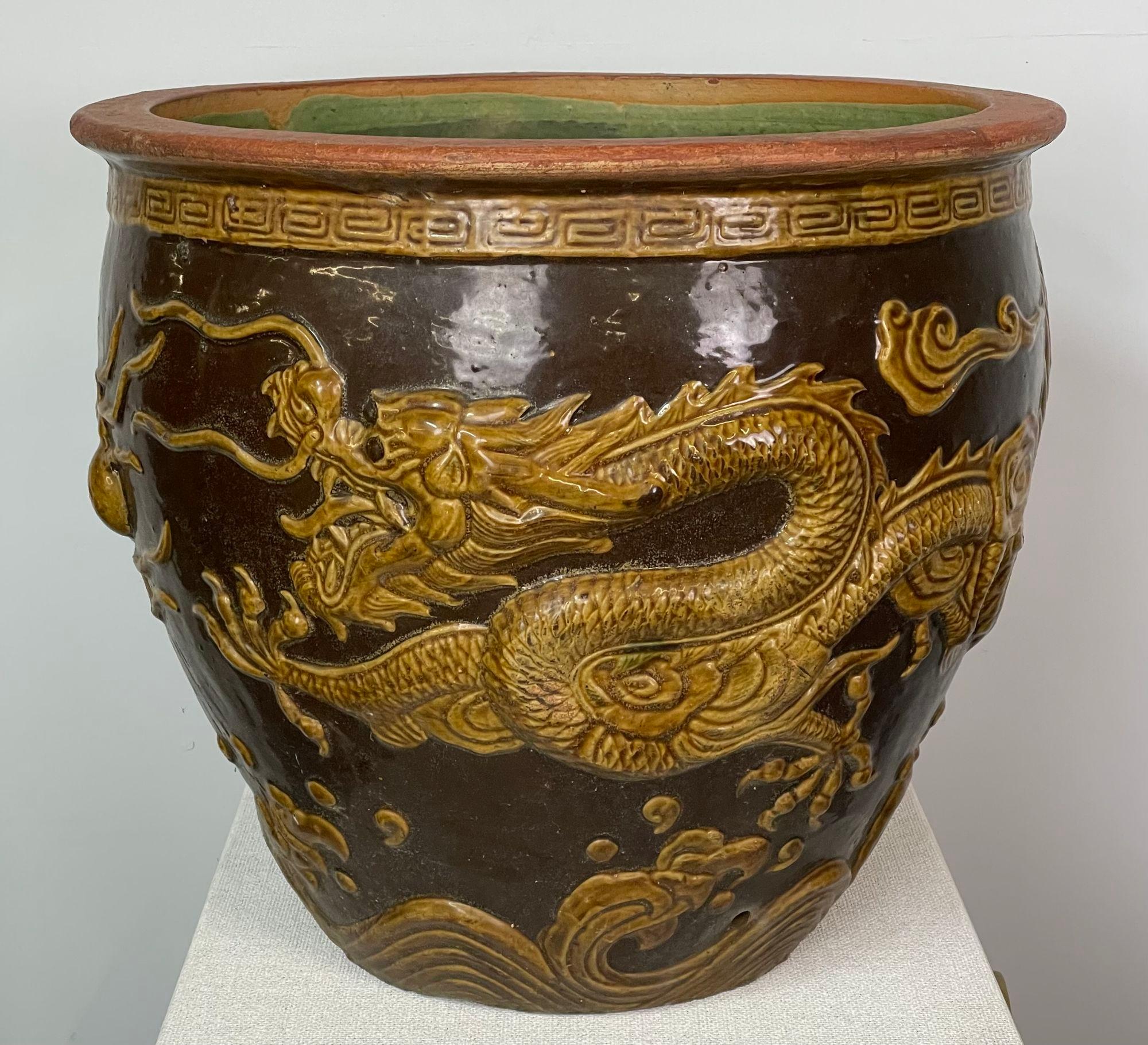 Dragon cachepot planter jardiniere fish bowl in Tony Duquette style
Asian jardiniere features raised detailed dragons in different shades of glazed earth tones and turquoise glaze on the inside. It has good balance and a pleasing silhouette; it has