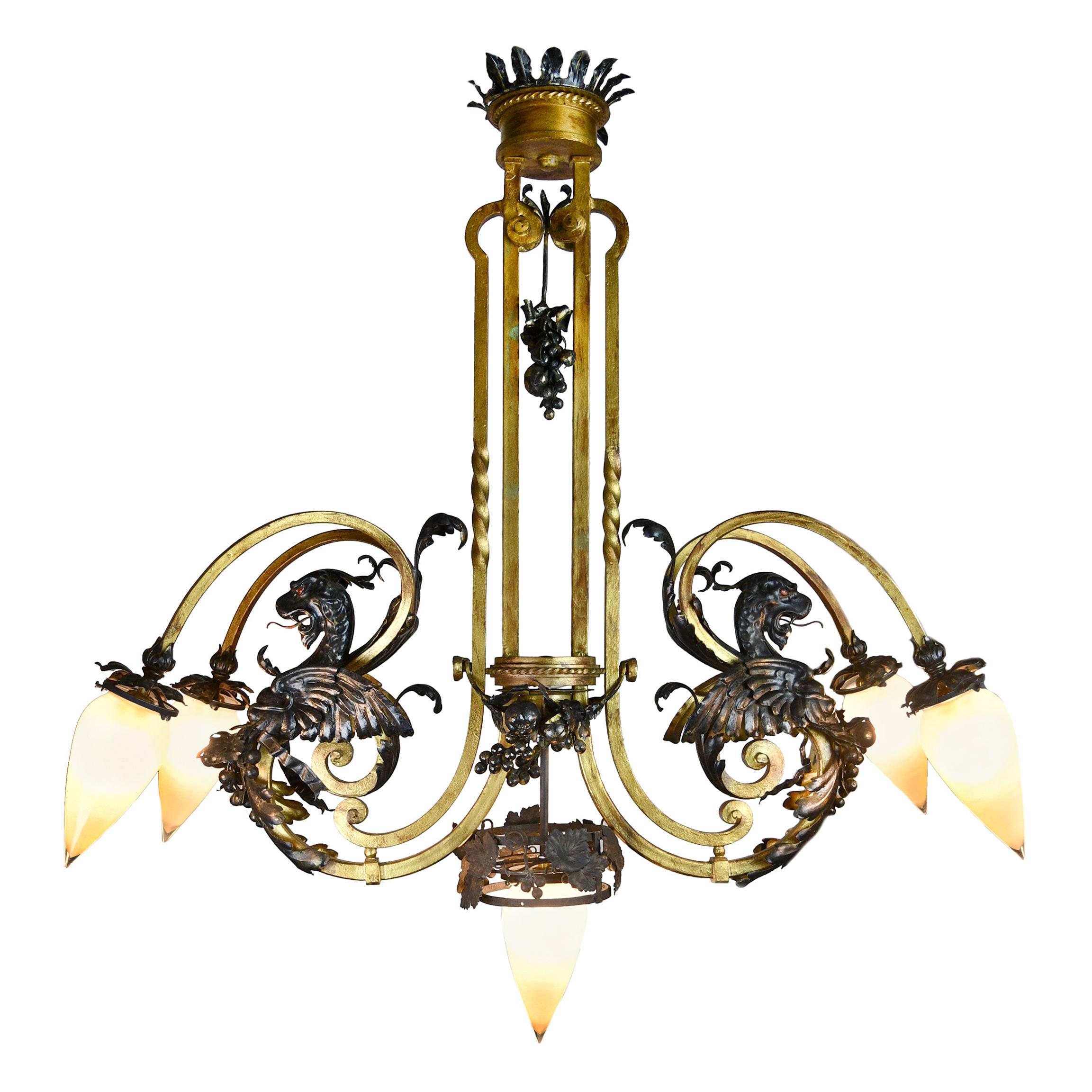 This beastly five-light torpedo chandelier has a lot to look at. From the crown of leaves that round the canopy down to the prominent form of the equally pointed frosted torpedo shades. This large light is mostly symmetrical, a pair of chimera’s