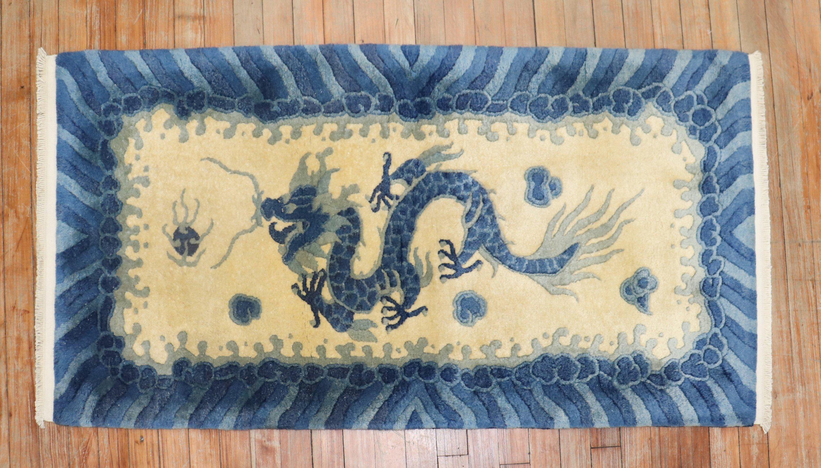 Ein vollfloriger chinesischer Teppich aus dem 3. Viertel des 20. Jahrhunderts mit einem blauen Drachen auf einem gelb-beigen Feld. Akzente in Blau.

Maße: 2'3