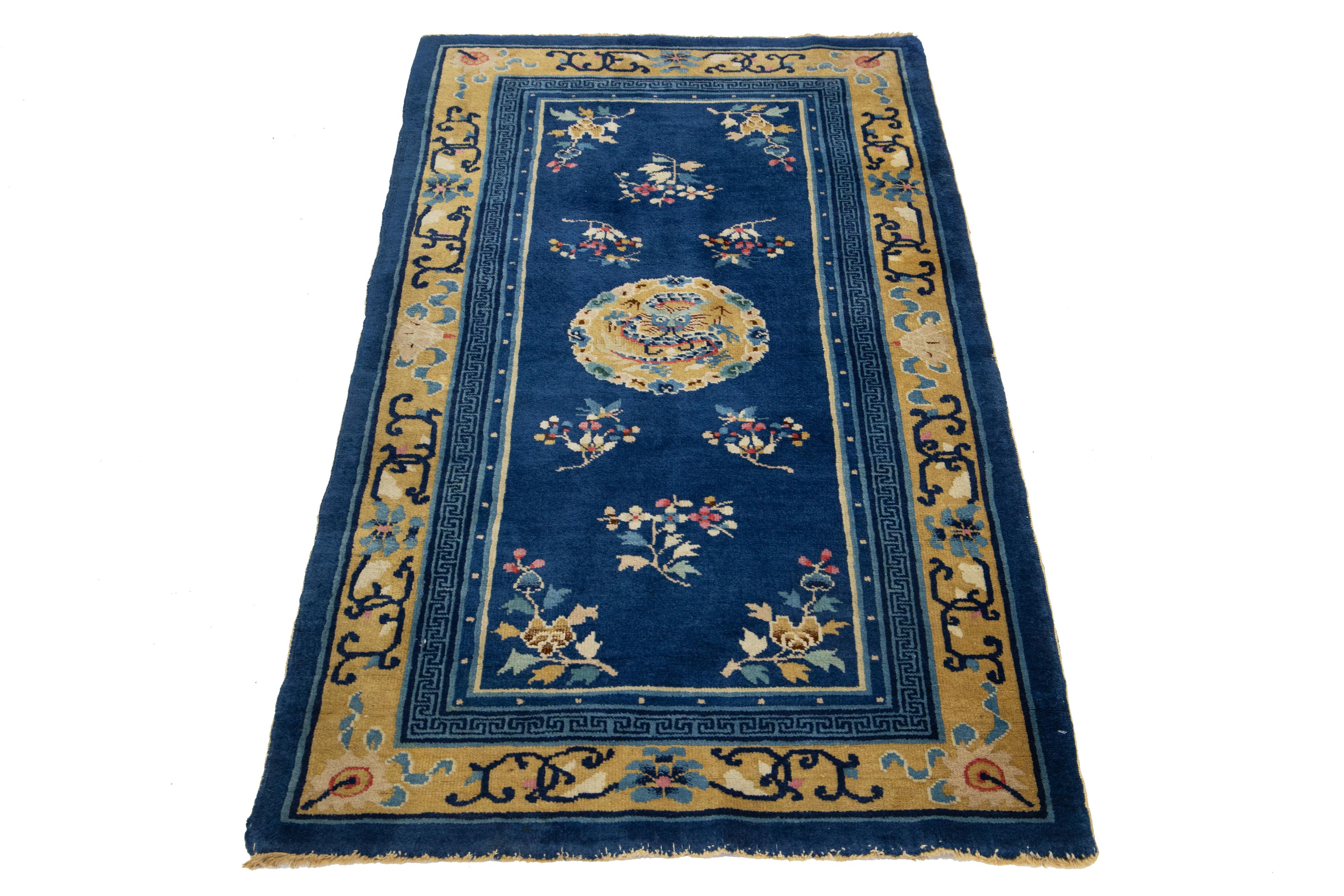 Ce superbe tapis ancien en laine nouée à la main de la Chine de Pékin présente un riche champ bleu marine orné d'accents jaunes vibrants mettant en valeur les motifs traditionnels des dragons chinois.

Ce tapis mesure 3'1