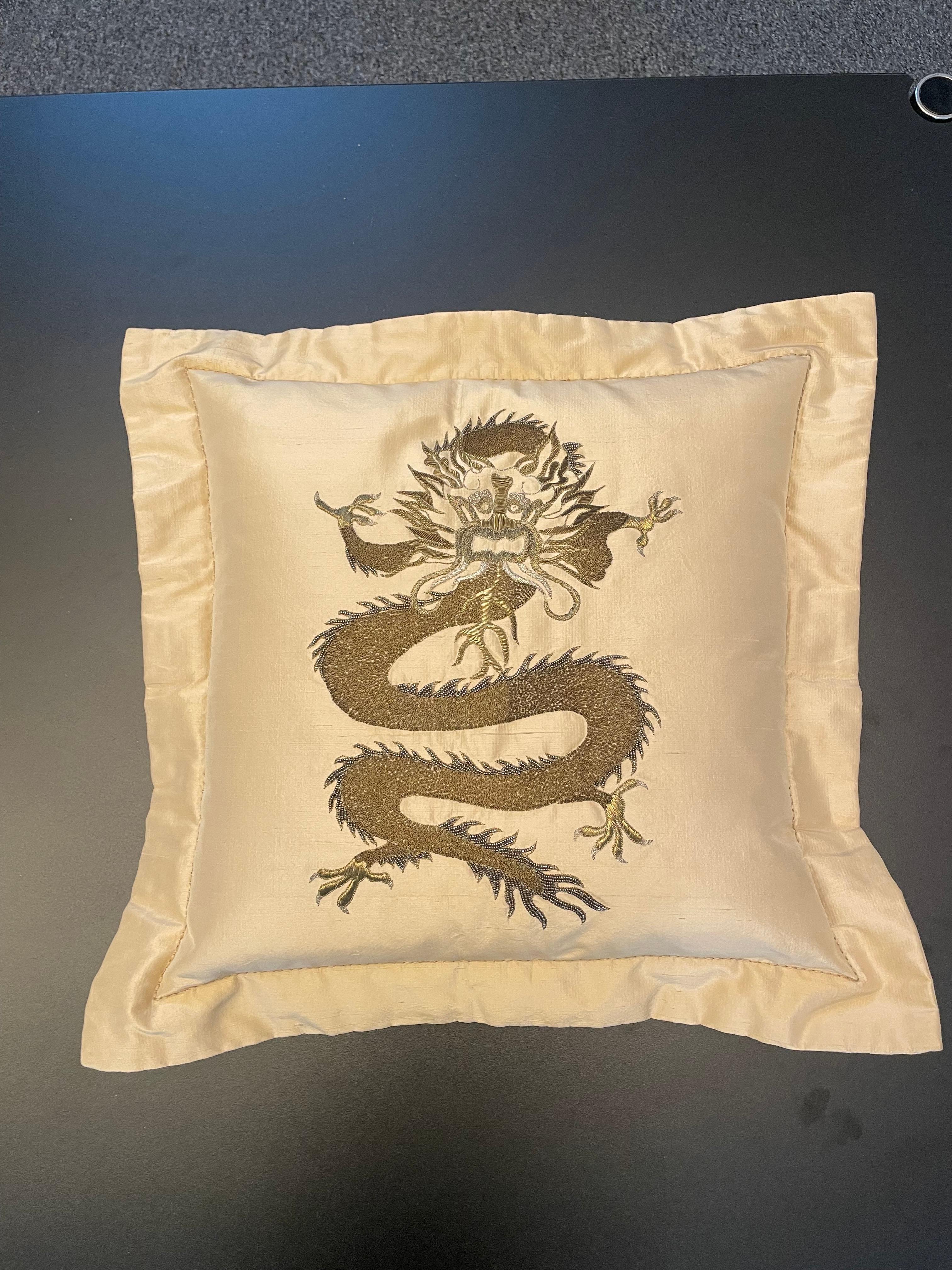 Cuscino in seta color paglia con disegno di drago ricamato a mano con filo d'oro in diverse tonalità, la fodera del cuscino ha come finitura un bordo 