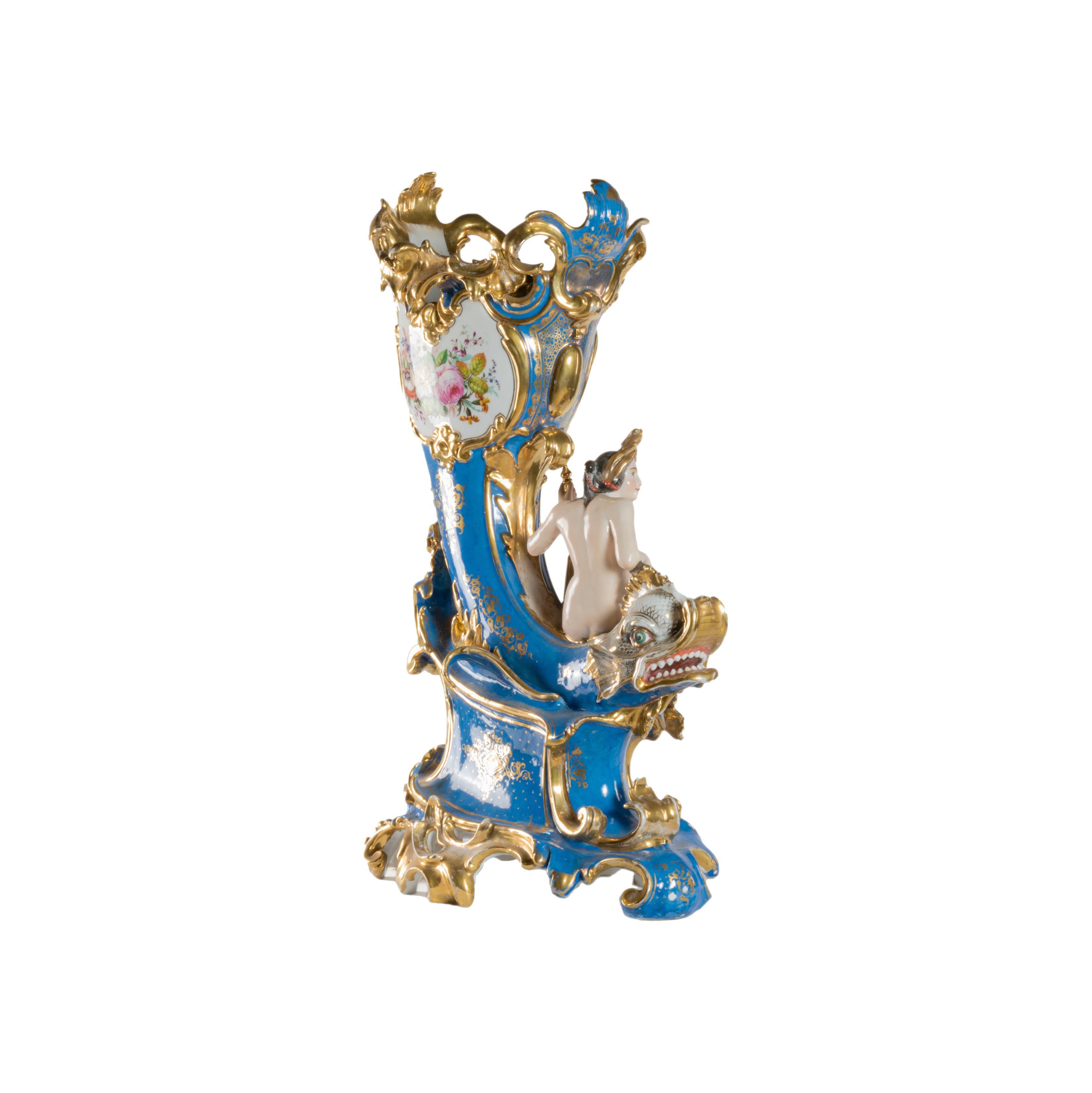 A striking vase adorned with a multicolored design depicting a dragon and a mermaid, symbolizing the mythical creature's transformation from carp to dragon. The background features a beautiful blue and gold hue, while the flowers add a touch of