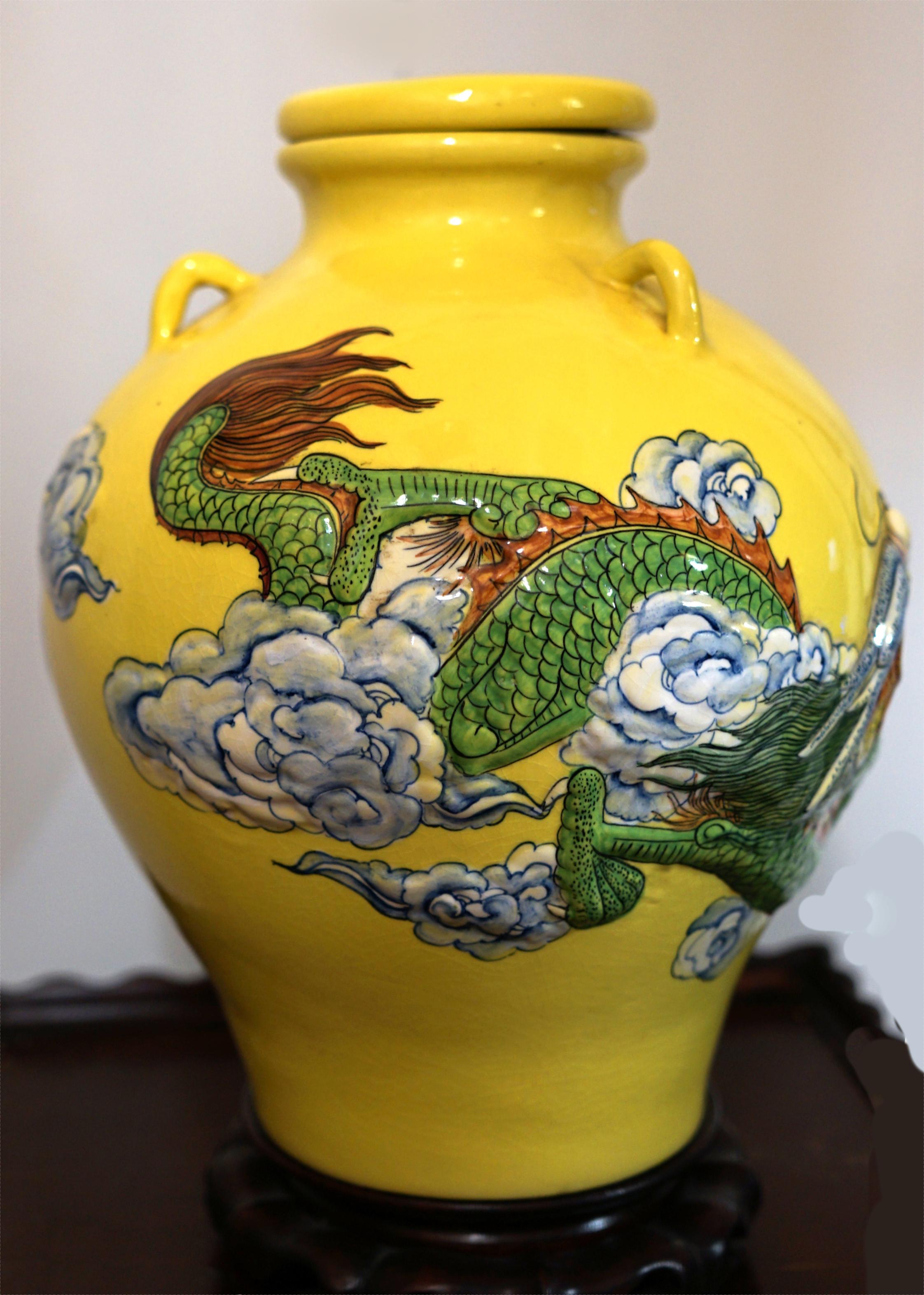 Few scenes are as compelling as a dragon aloft in high relief as it moves through clouds and the atmosphere of a glazed enamel background in yellow.
The Yellow Ceramic Jar adorned with a top and high-relief design features a majestic dragon,