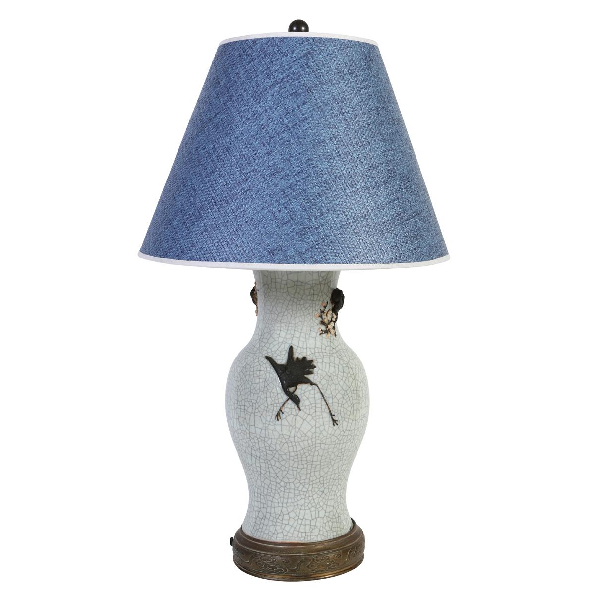 Cette étonnante lampe asiatique en céramique présente une finition traditionnelle de glaçure craquelée qui ajoute de la profondeur et de la texture à sa surface. Un puissant motif de dragon s'enroule gracieusement autour du corps, évoquant la force