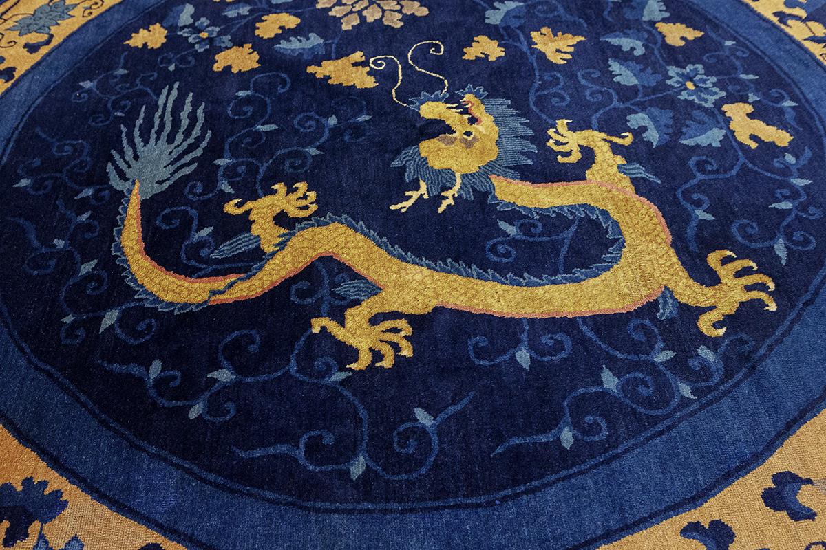 Dieser exquisite antike Drachenteppich aus Peking ist ein bemerkenswertes Artefakt historischer Kunstfertigkeit, das einen Einblick in die hochentwickelten Teppichknüpftraditionen des alten China bietet. Der mit Sorgfalt gefertigte Teppich hat einen