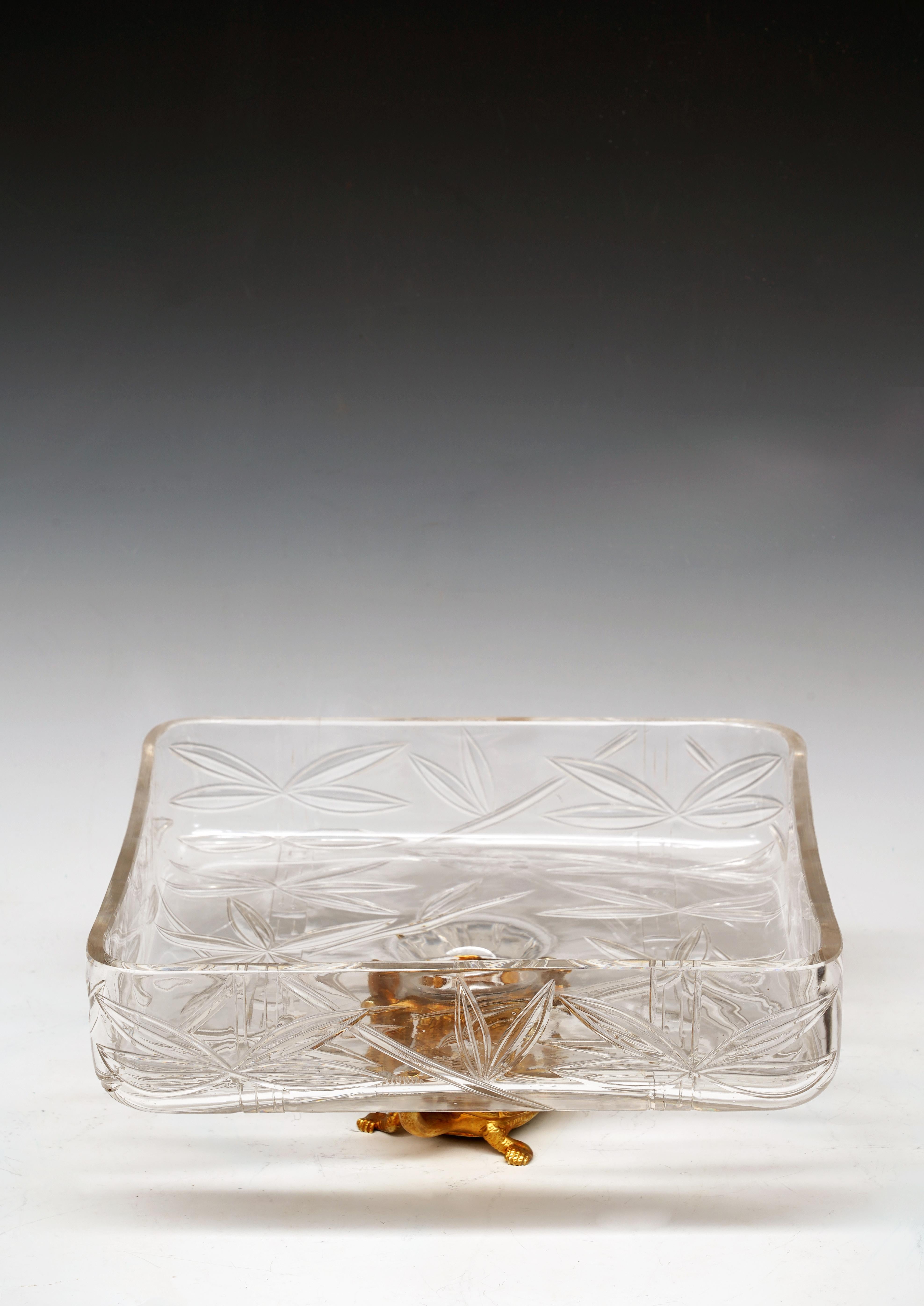 Belle coupe de forme carrée en cristal gravé, décorée de bambous et d'oiseaux.
Elle repose sur une tortue-dragon en bronze doré, créature légendaire chinoise au corps de dragon et à la carapace de tortue, symbole de puissance et de