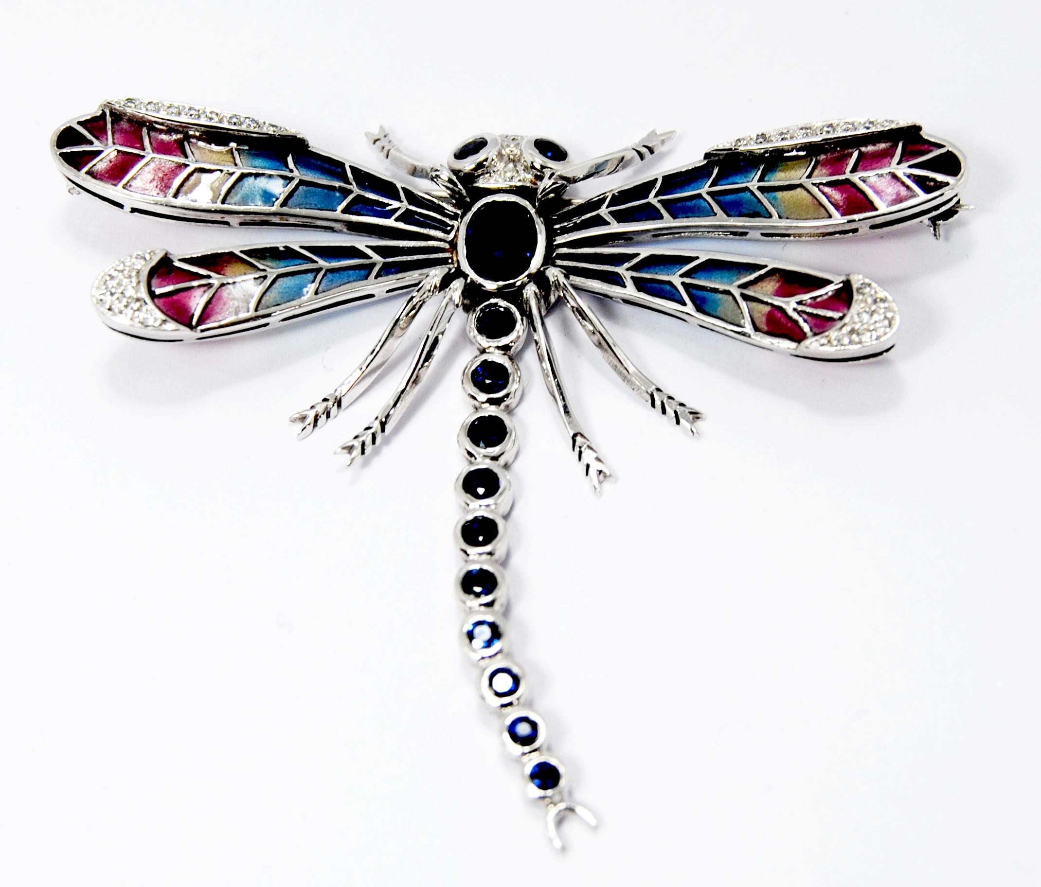An exquisite an art nouveau style  dragonfly brooch, with multicolored plique à jour  wings, with oval sapphire set in the centre, weighing an estimated 3.00ct, and 12 round saphphires in eyes and body totalling 16ct of sahhpires, wings are