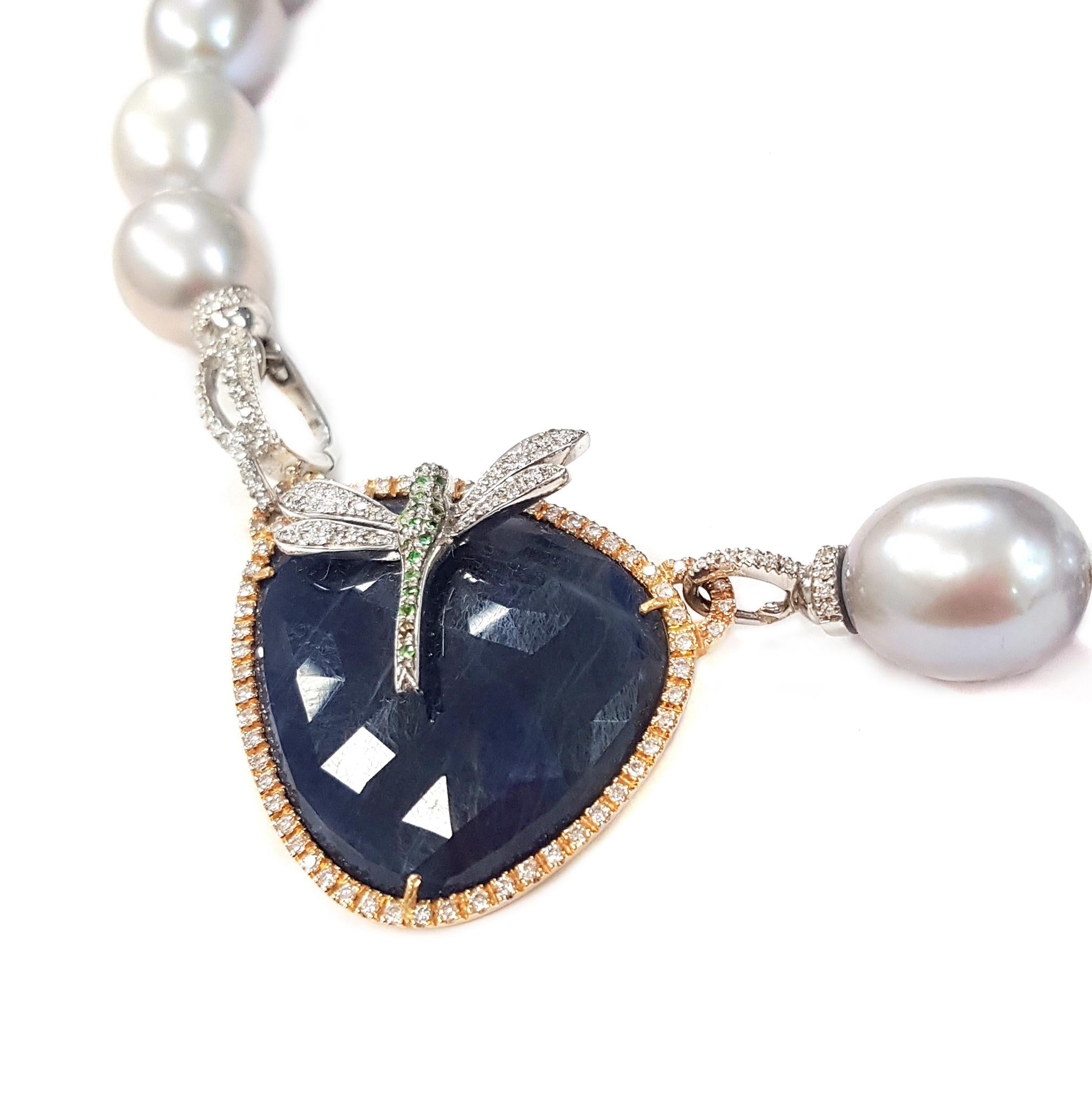 A gorgeous necklace of large silvery freshwater pearls, each about 1 centimetre in diameter, is completed by a large blue sapphire pendant. The pendant is framed with 18-karate rose gold and set with white diamonds. It supports a dainty white
