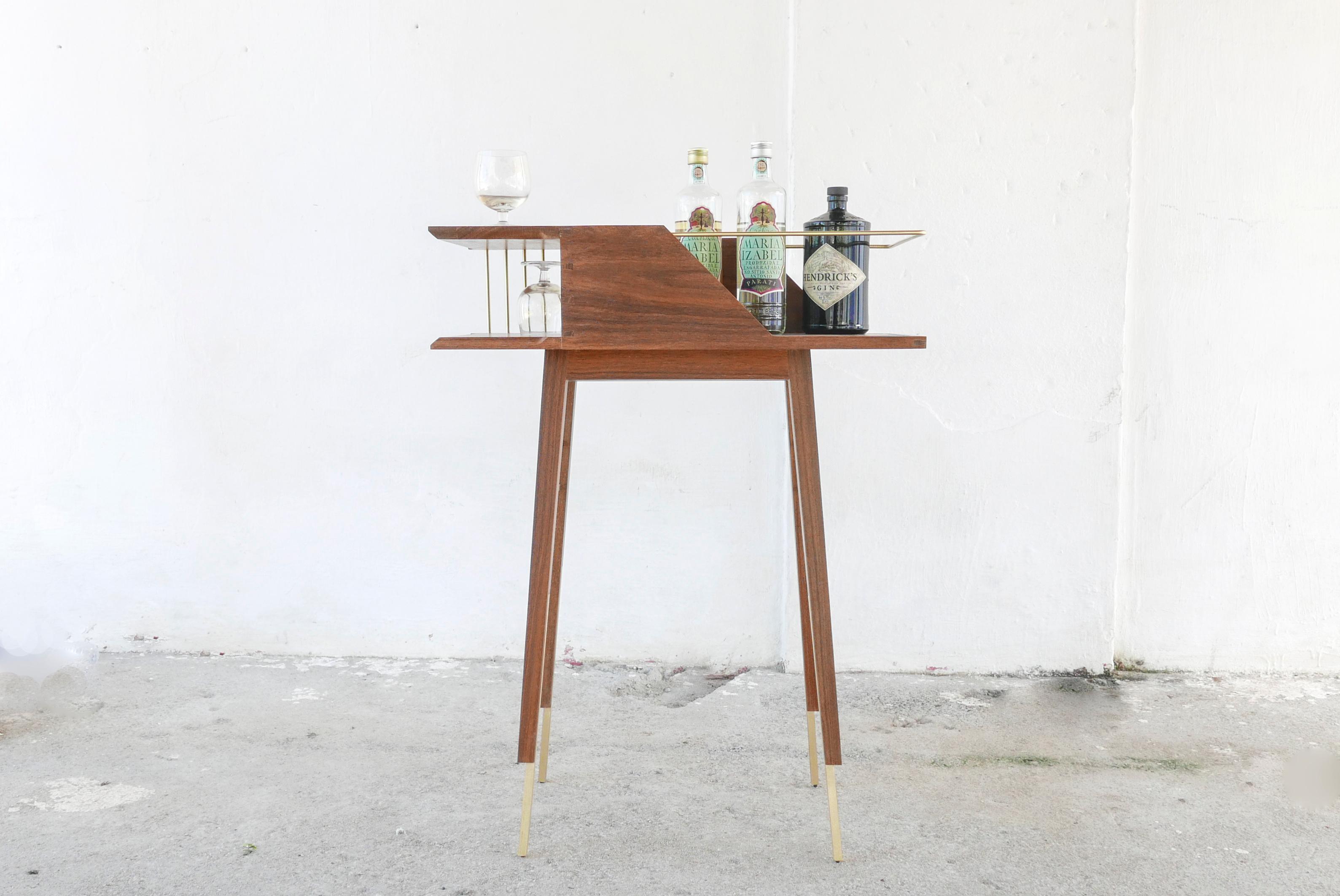 Dram dry bar is defined by its open spaces and marked by its sculpted angles and brass components which add levity and delicacy. It is a mid-century modern inspired piece with a minimalist feel and entirely contemporary though traditionally