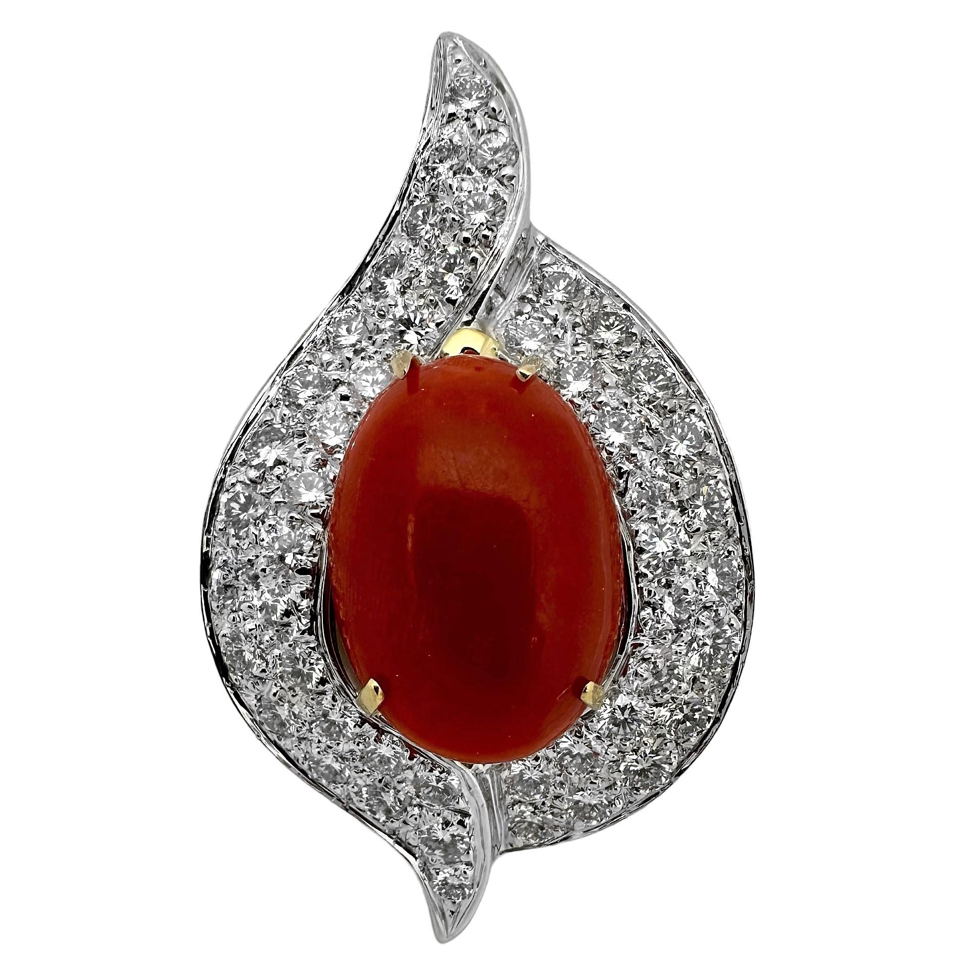 This very dramatic vintage pendant by designer Emis Beros, is expertly crafted in 18k white gold. The oval vivid orange coral cabochon in the center is set in a yellow gold basket which measures almost 3/4 inch by 1/2 inch. This very fine quality