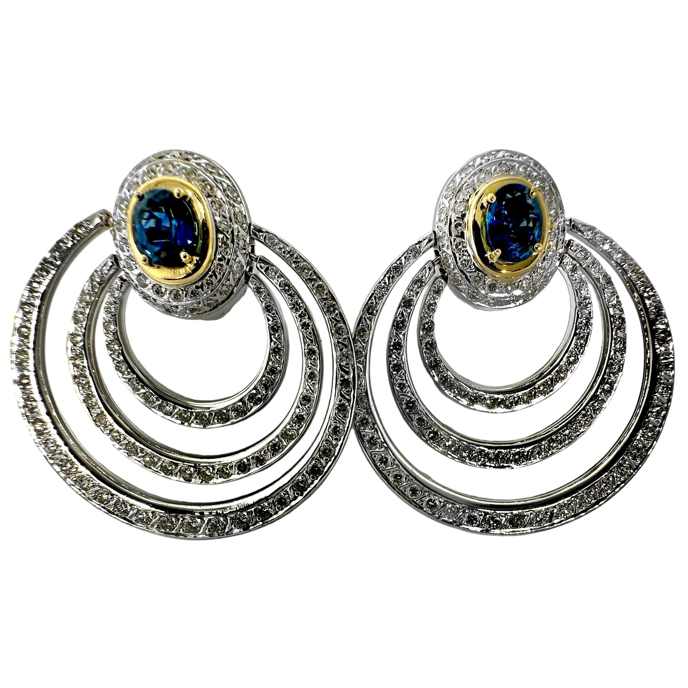 This outstanding pair of precision crafted and very dramatic Repossi Italian hoop earrings is set with in excess of two hundred brilliant cut diamonds and two oval faceted rich blue natural sapphires. Total approximate diamond weight is 9.00ct of