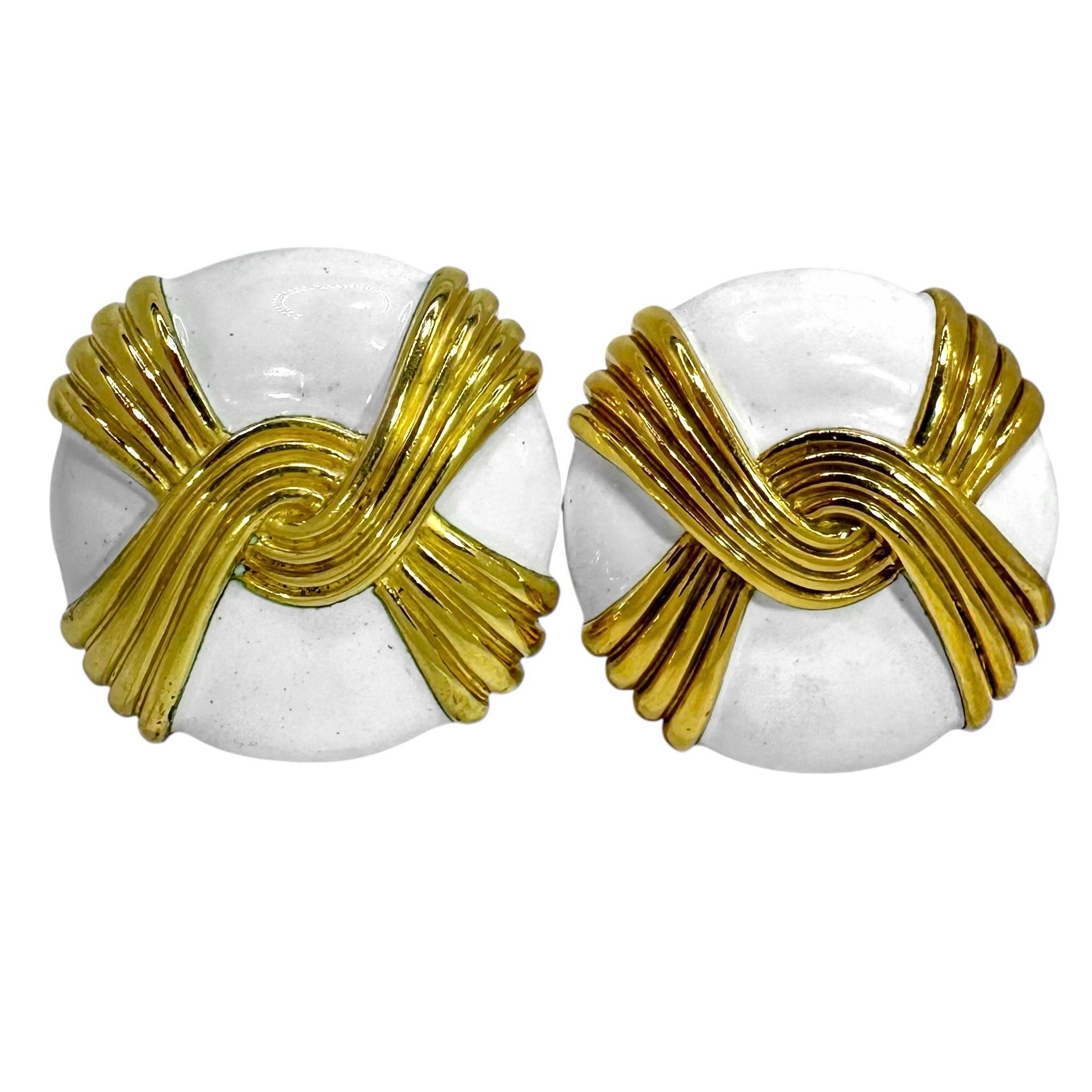 Diese auffälligen Ohrringe von Andrew Clunn zeigen ein erhabenes Flechtmotiv aus 18-karätigem Gold vor einem Hintergrund aus glänzender weißer Emaille. Die Wirkung ist fesselnd, kühn und maßgeschneidert zugleich. Diese Clip-on, Knopf Ohrringe messen