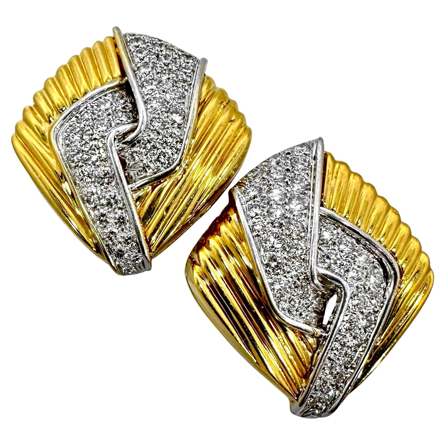 Wonderful style, quality and drama combine here to create this palpable 1970's jewelry creation. This very dimensional pair of clip on cocktail earrings fashioned from rich 18K yellow gold features four intertwined white gold plates set with a total