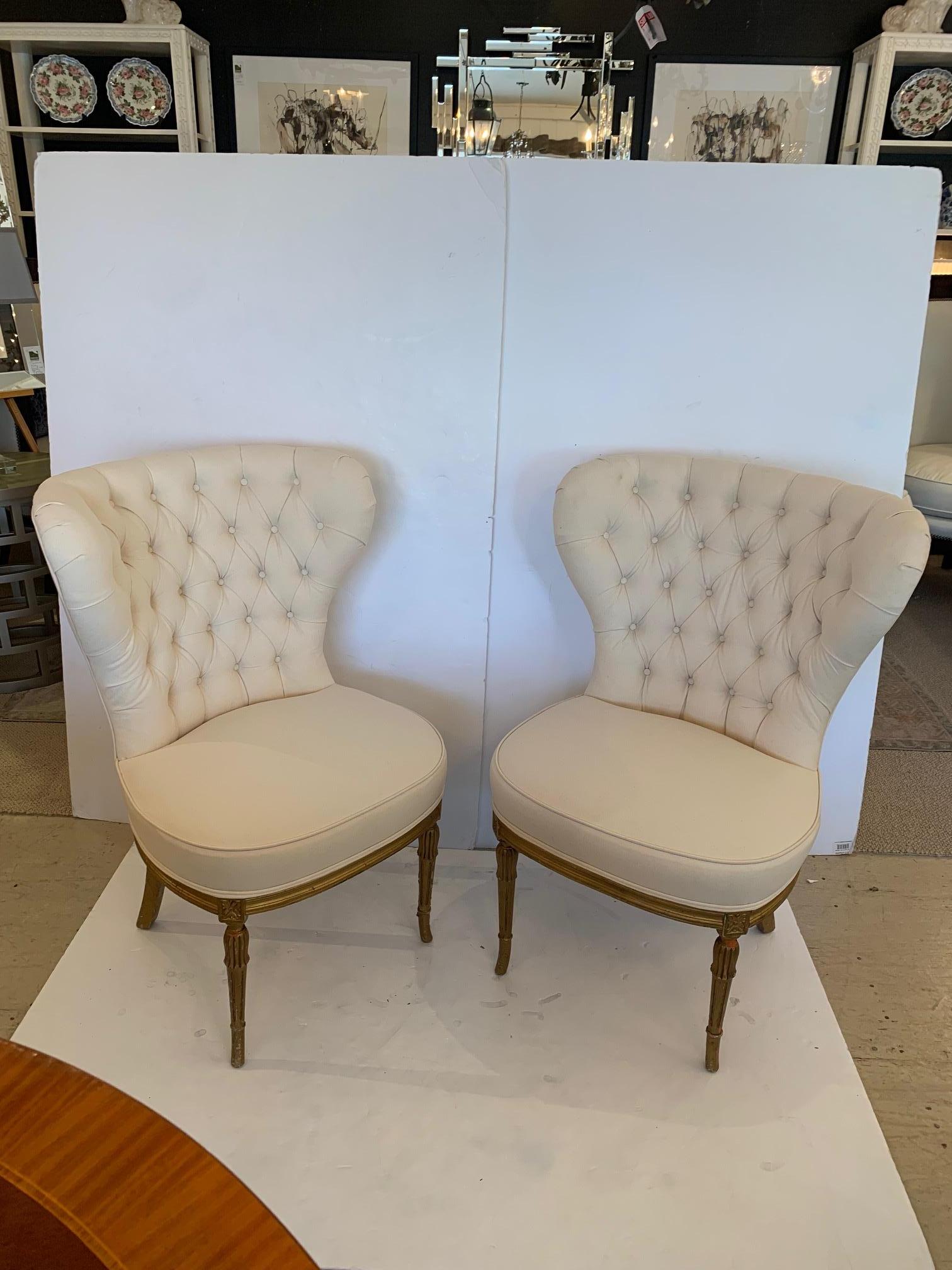 Super glamorous pair of French fan back tufted slipper chairs having wonderfully shaped balloon seats and brand new high quality white duck upholstery. Carved wooden bases have fabulous aged gilding with some original red underpaint showing through