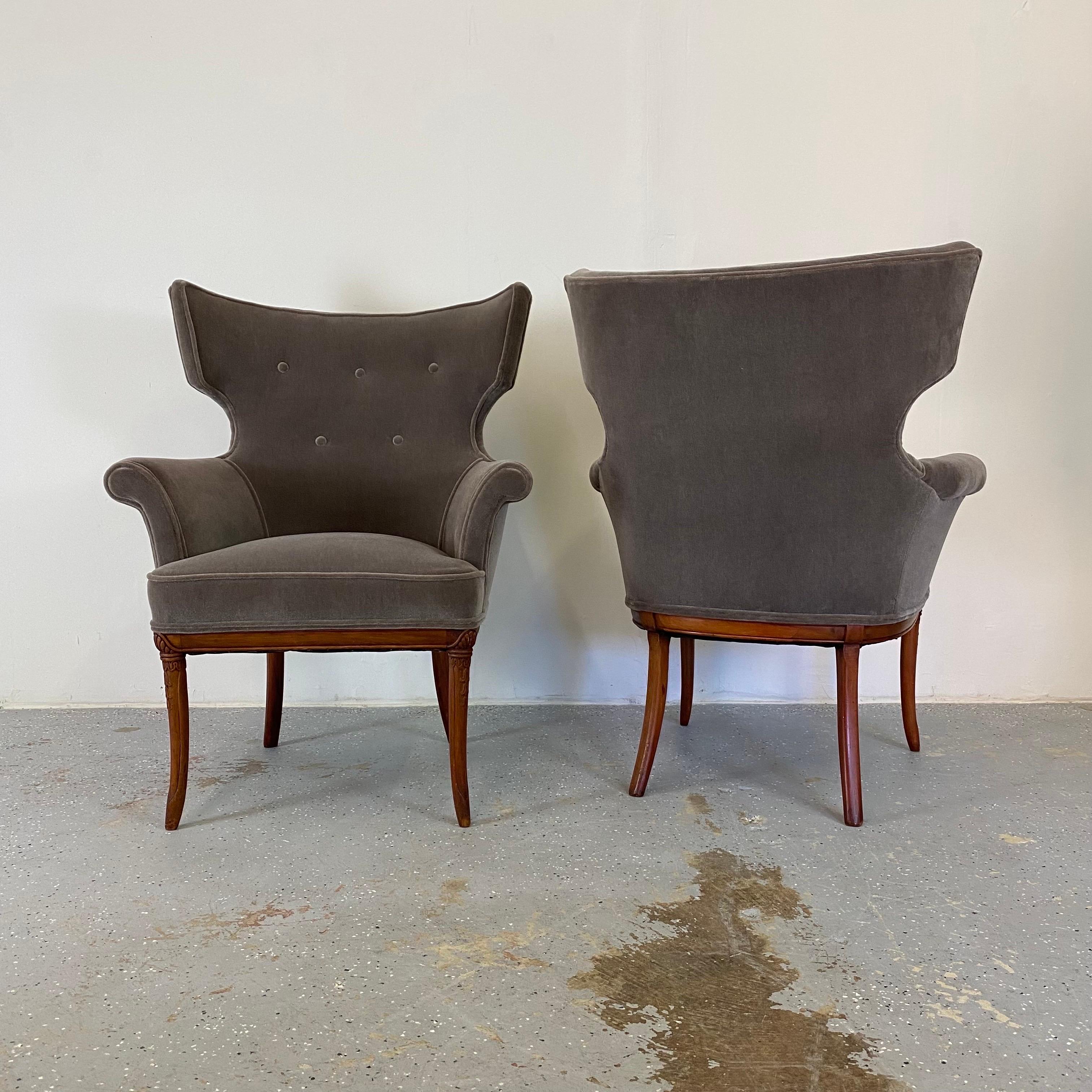 An elegant pair of antique wingback chairs. These have dramatic silhouettes with new mohair upholstery.